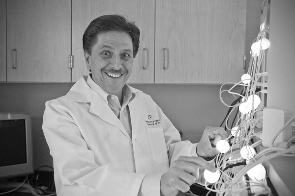 A scientist laughing next to a device. | Photo: Flickr