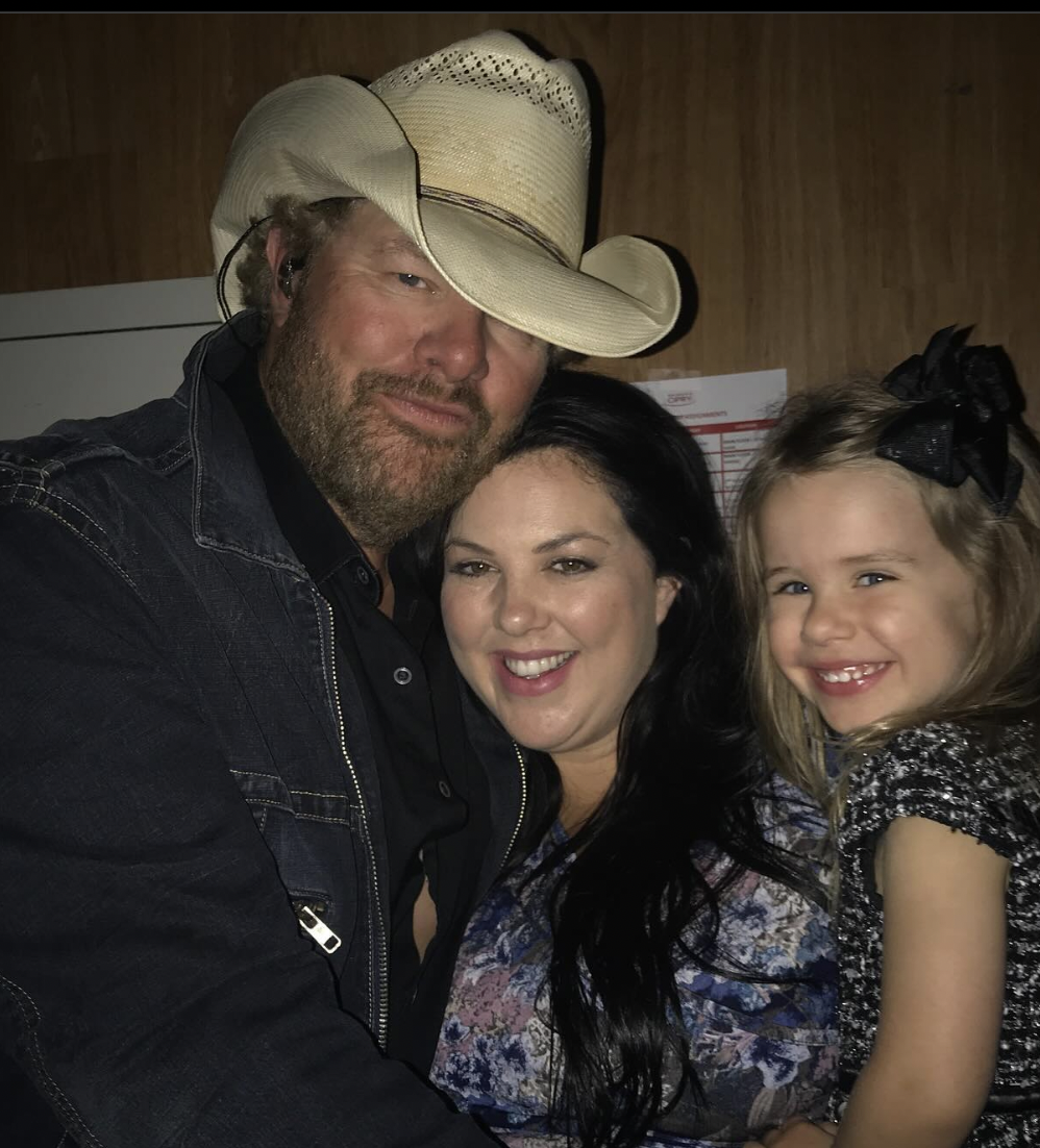 Toby Keith posing for a photo with Krystal Keith and his granddaughter, posted on February 10, 2024 | Source: Instagram.com/krystalkeith/