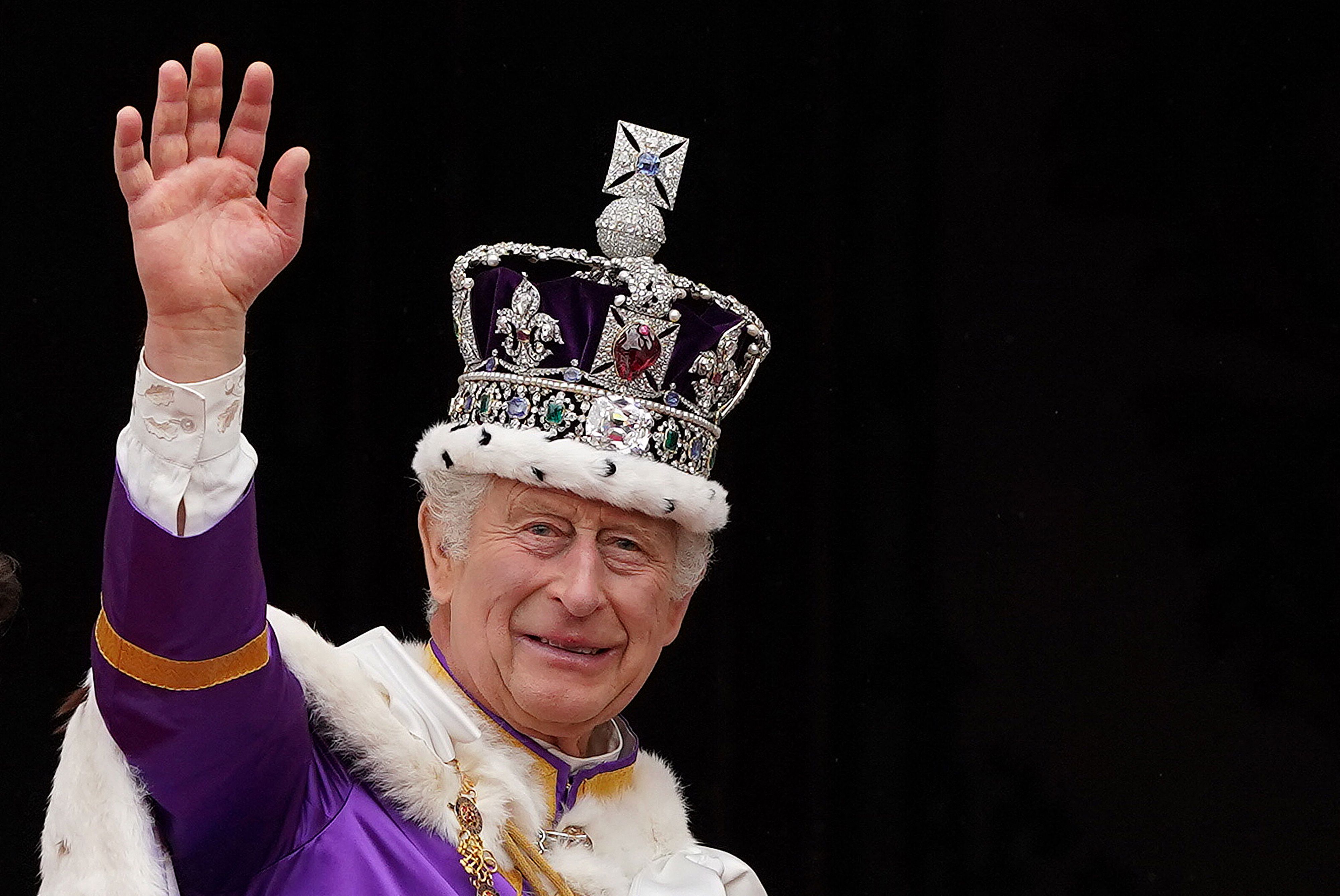 King Charles III wearing the Imperial state Crown as he waves from the Buckingham Palace balcony after viewing the Royal Air Force fly-past in central London on May 6, 2023, after his coronation | Source: Getty Images