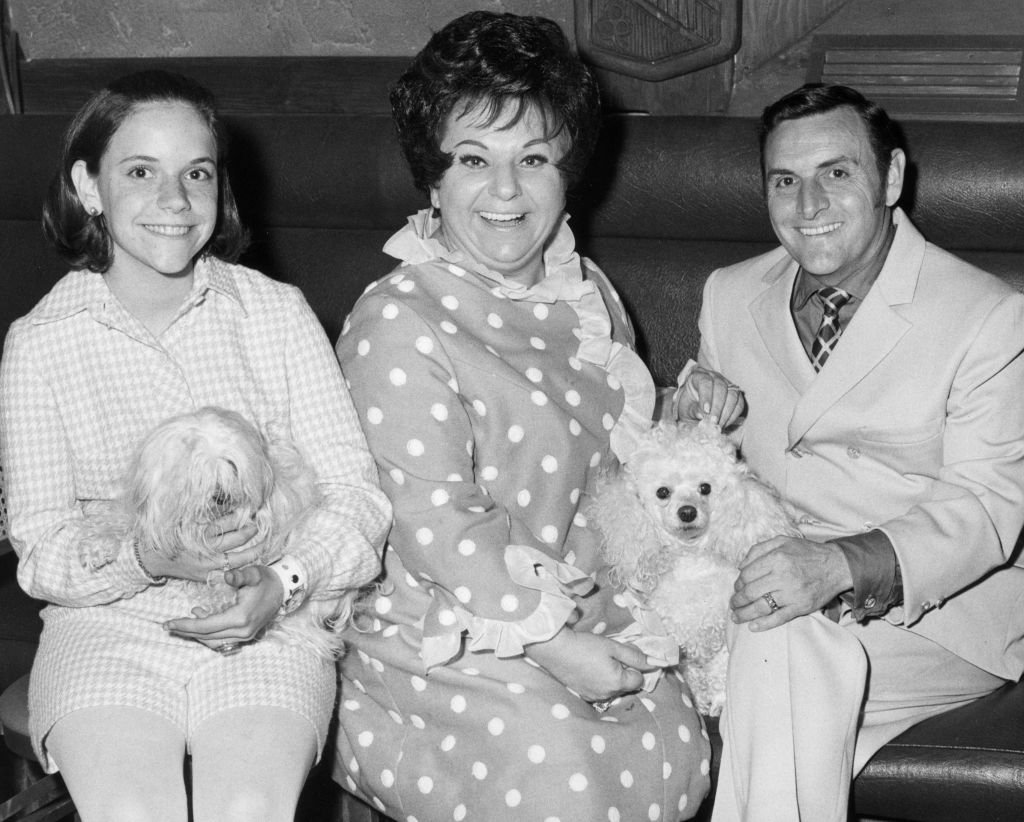 Totie Fields with her husband, George, their daughter, Debbie, and their two dogs while taking a family portrait on January 01, 1965 | Photo: Getty Images