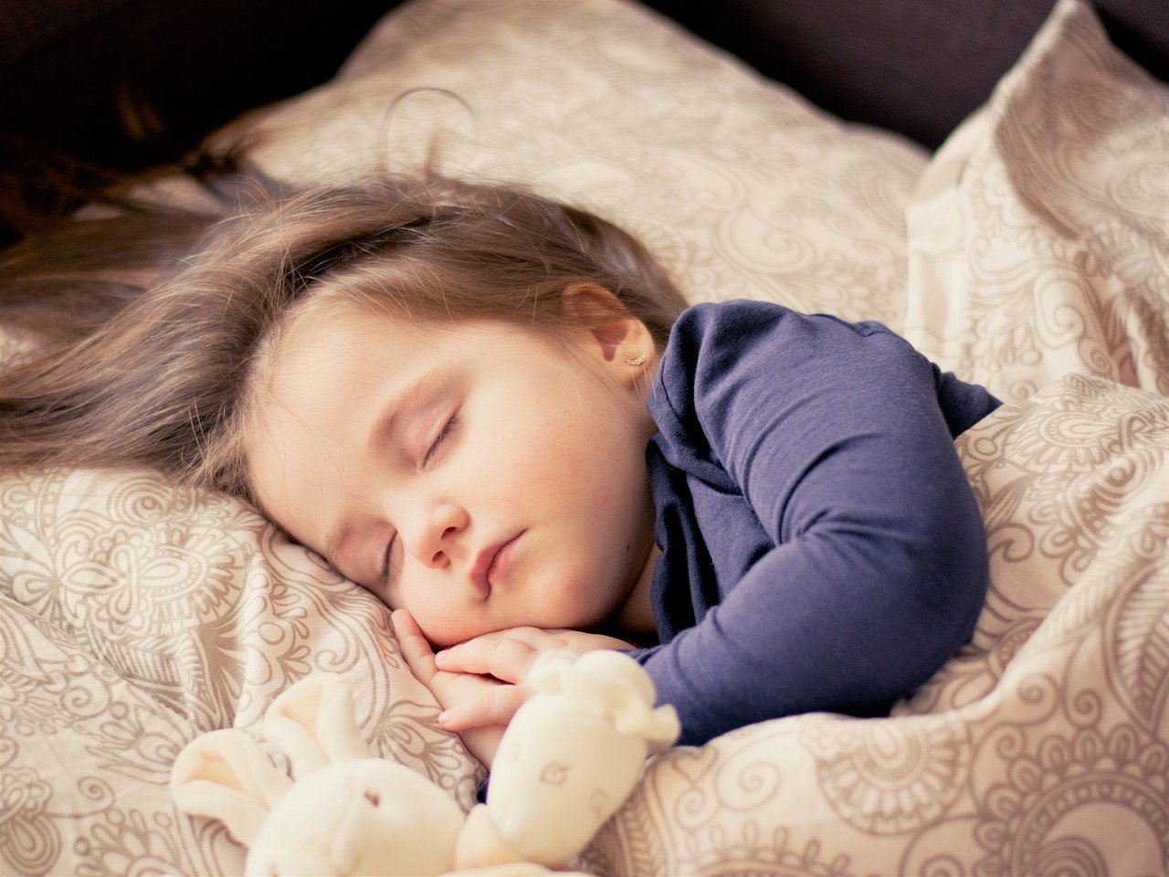 Niña durmiendo con un peluche. | Foto: Pixabay
