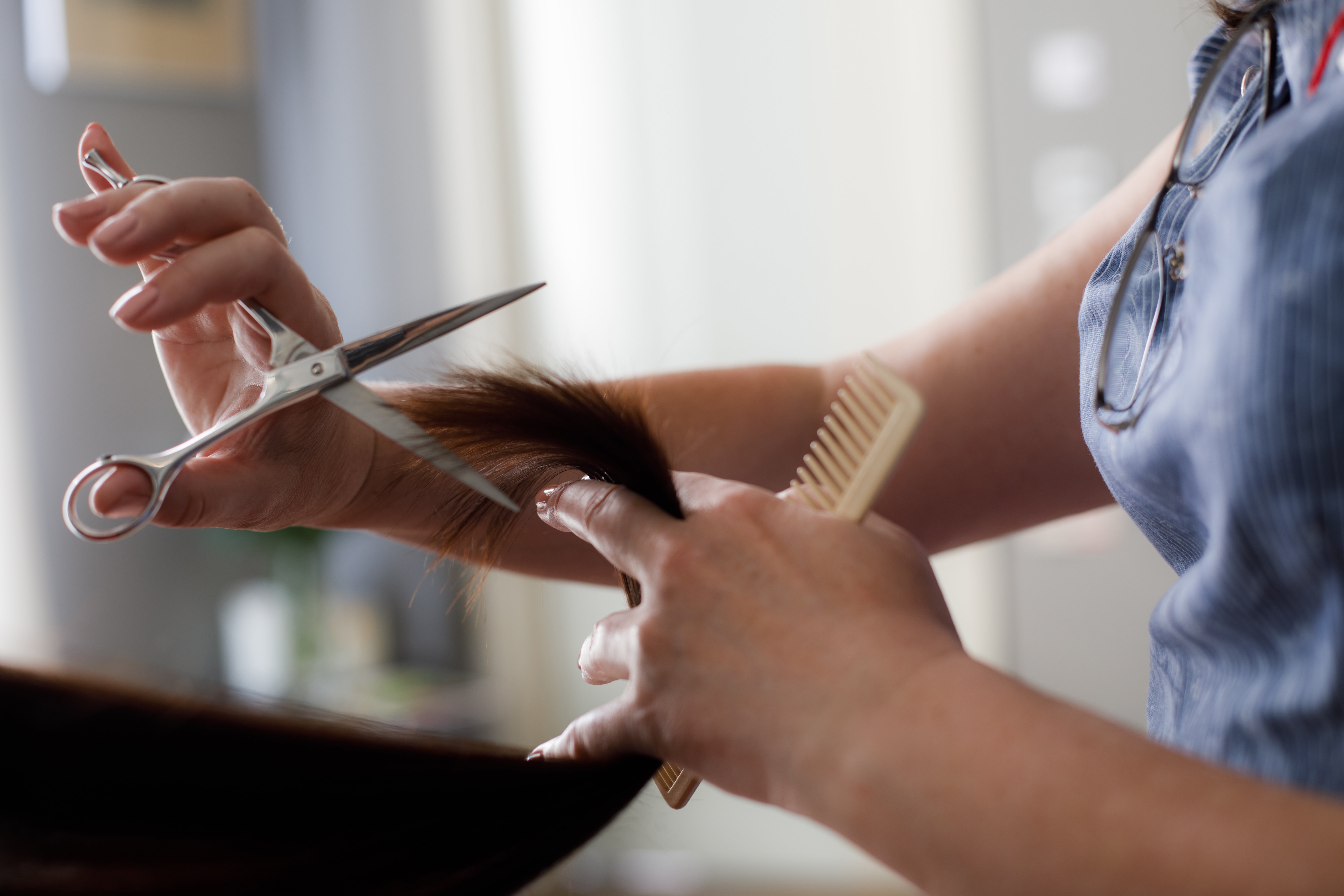 Nahaufnahme der Frau, die Haare schneidet | Quelle: Shutterstock