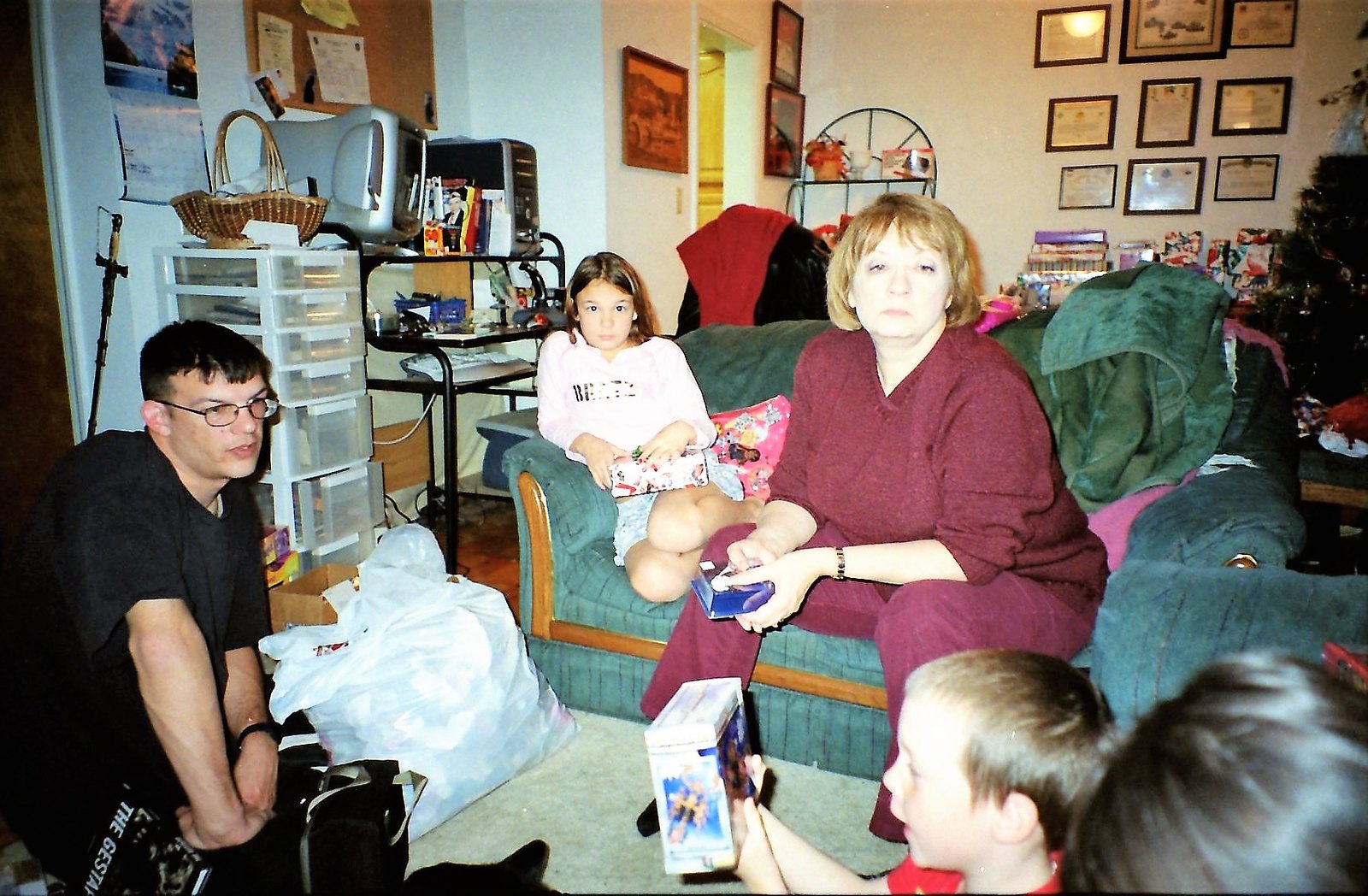 Family members watching their little boy open his Christmas present | Source: Flickr