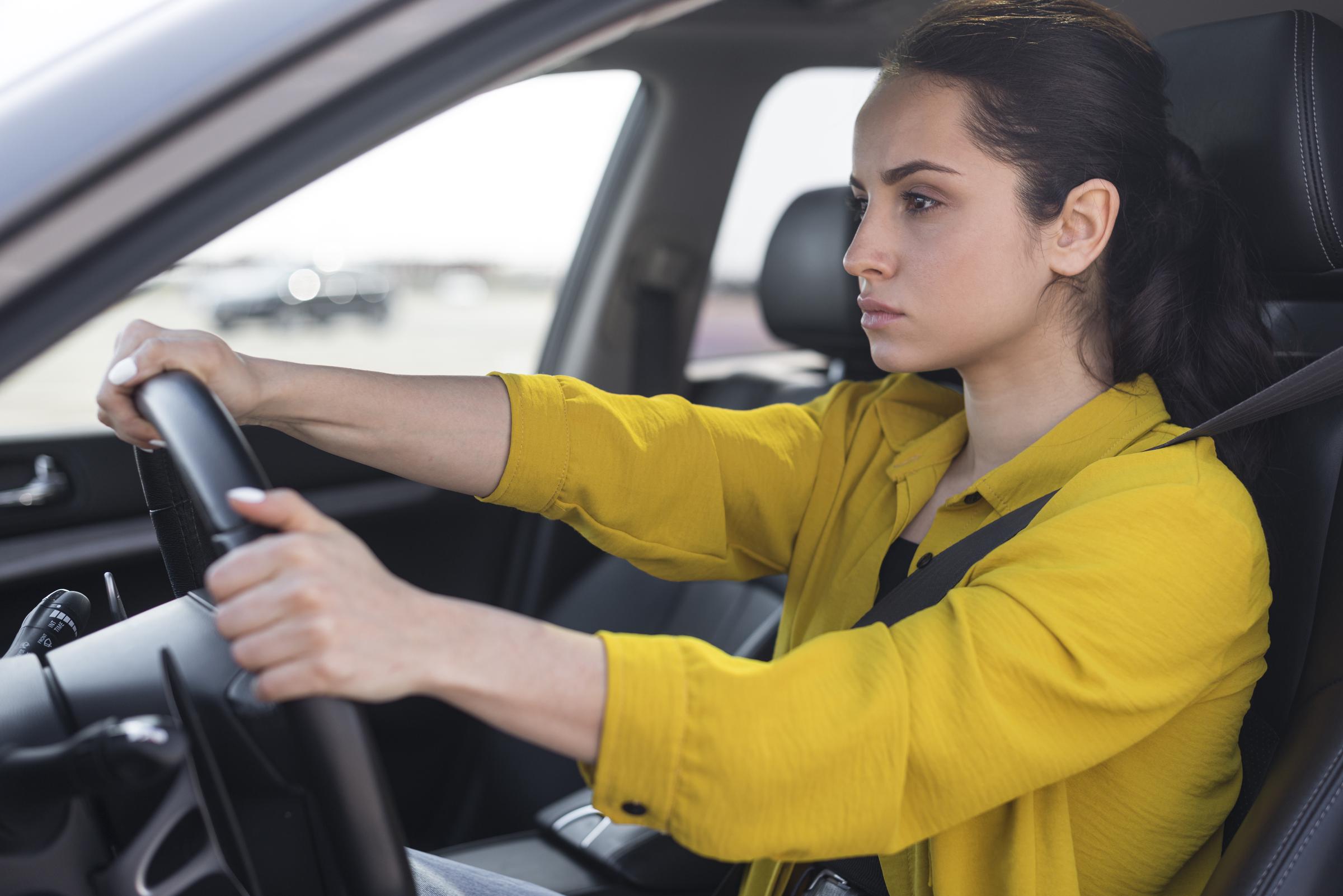 A frustrated young woman driving a car | Source: Freepik