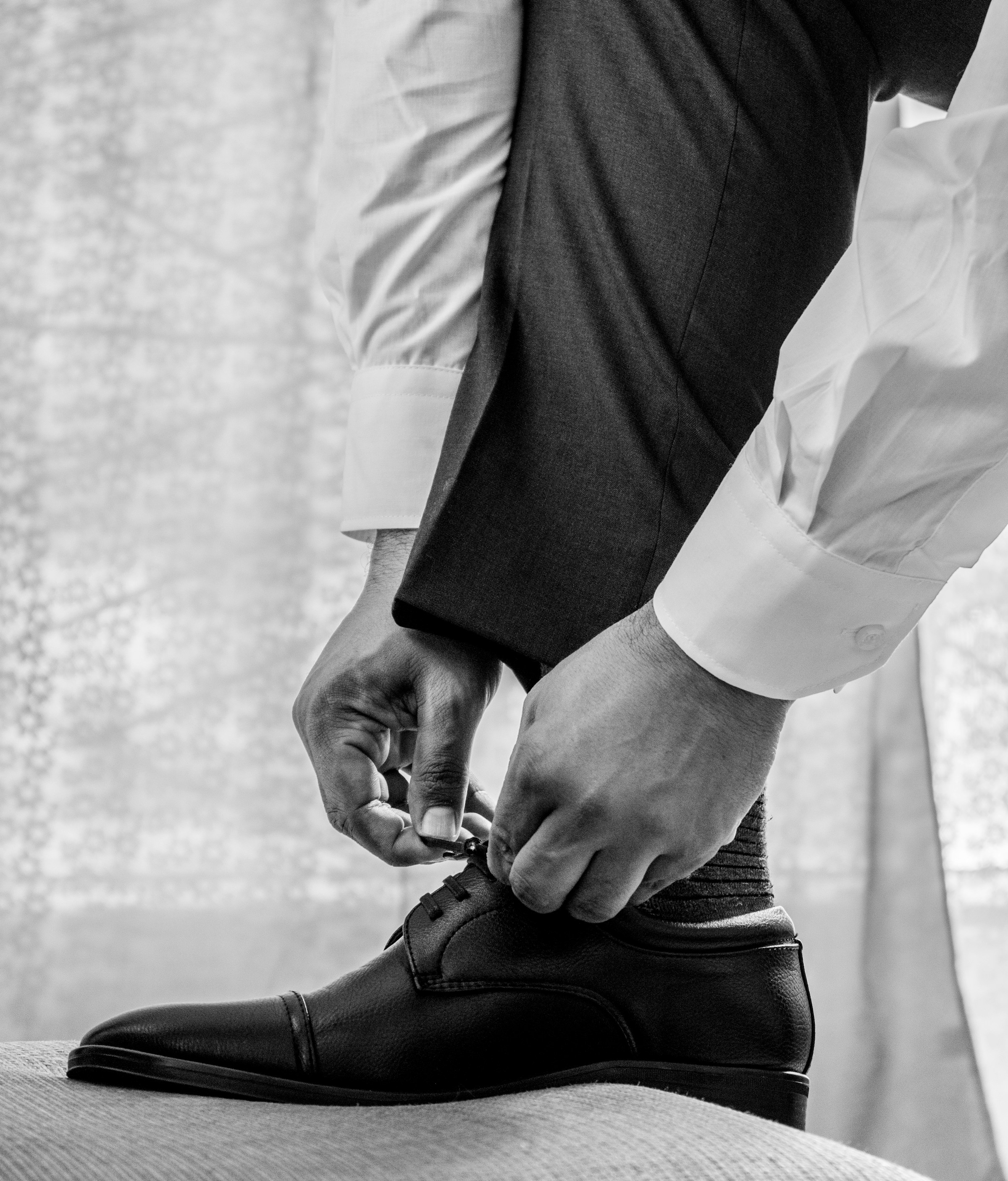 An extreme close-up shot of a man in a white dress shirt and black pants wearing black leather shoes | Source: Unsplash