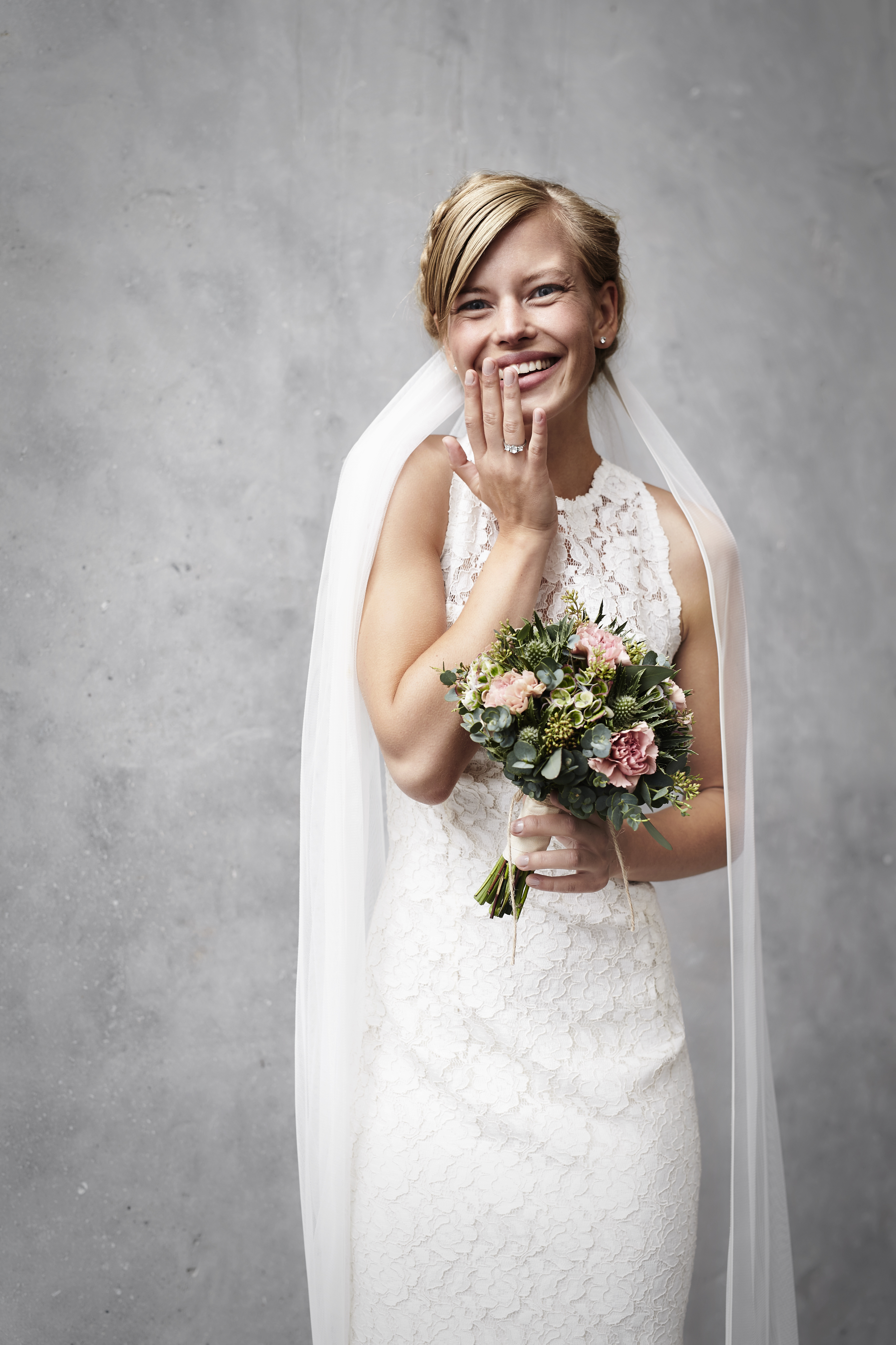 A bride giggling as she holds her bouquet | Source: Shutterstock