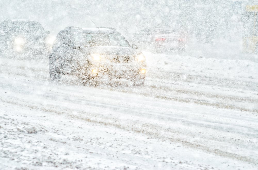 A car rides through a snowstorm. | Photo: Shutterstock