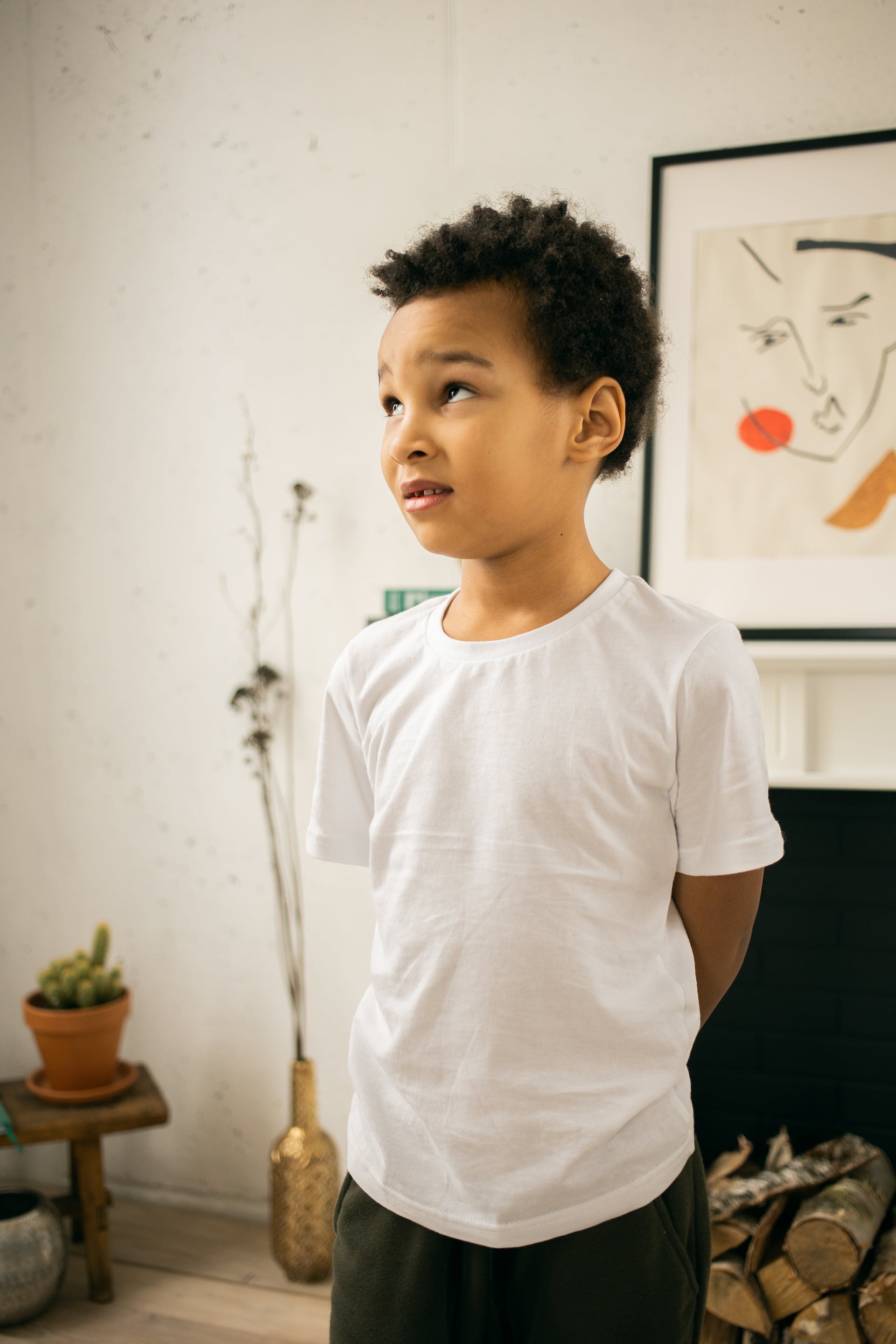 A child standing with his hands behind his back | Source: Pexels