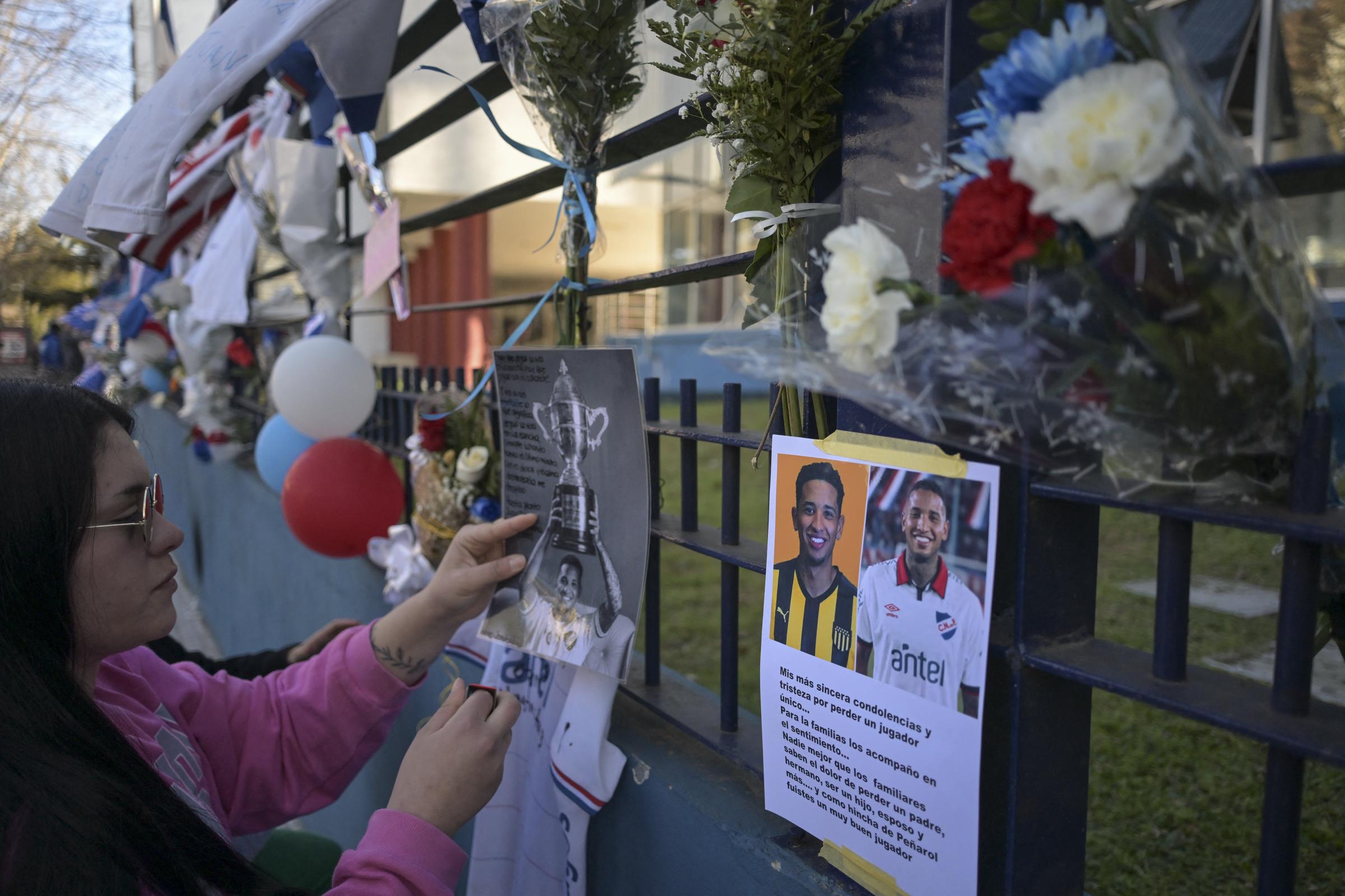 A woman pays tribute to late Uruguays Nacional football player Juan Manuel Izquierdo at the clubs headquarters in Montevideo, on August 28, 2024. | Source: Getty Images