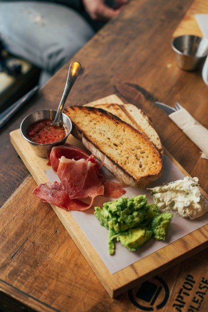 Jamón ibérico acompañado de tostadas. │Foto: Freepik