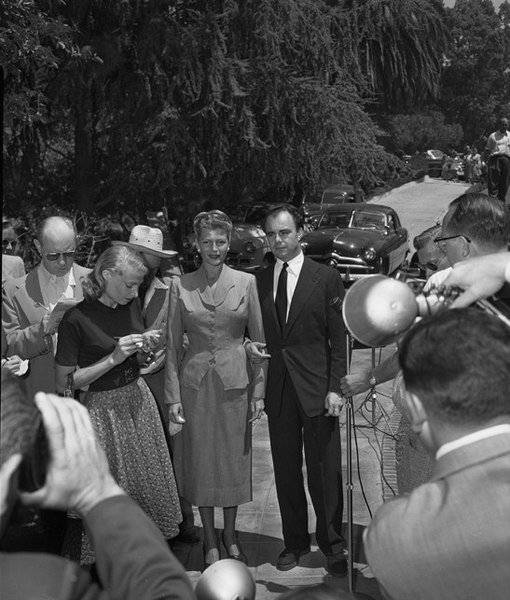 Rita Hayworth and Aly Kahn surrounded by reporters outside Hayworth's home, 1952. | Source: Wikimedia Commons