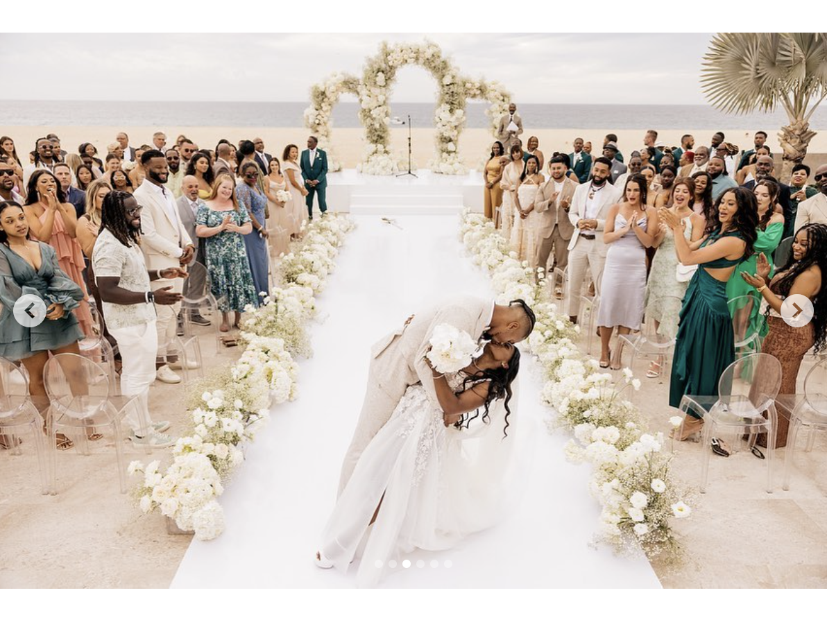 Simone Biles kisses Jonathan Owens as the guests watch and clap on their wedding day, as seen in a post dated May 9, 2023 | Source: Instagram/simonebiles