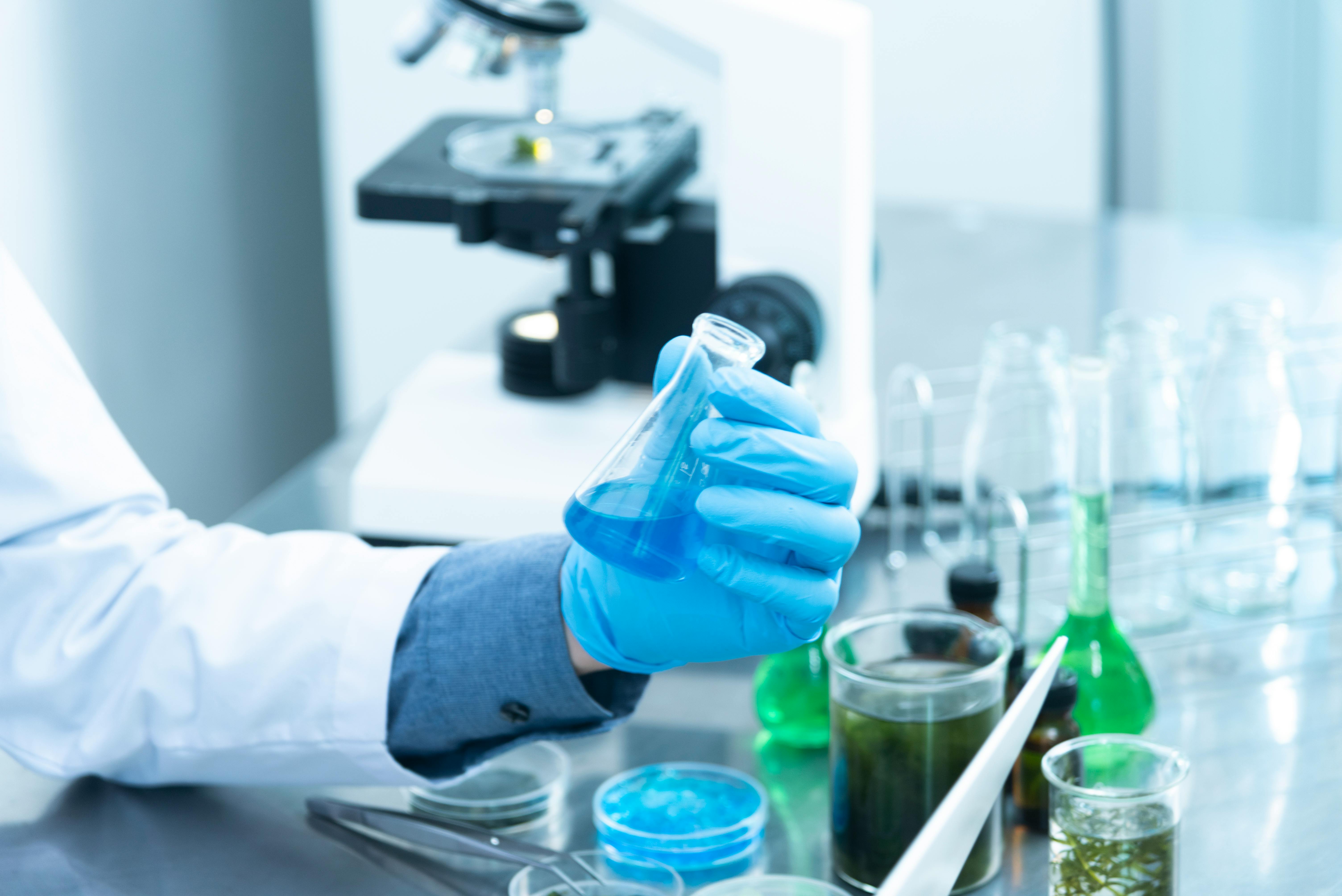 A person holding a laboratory flask. | Source: Pexels