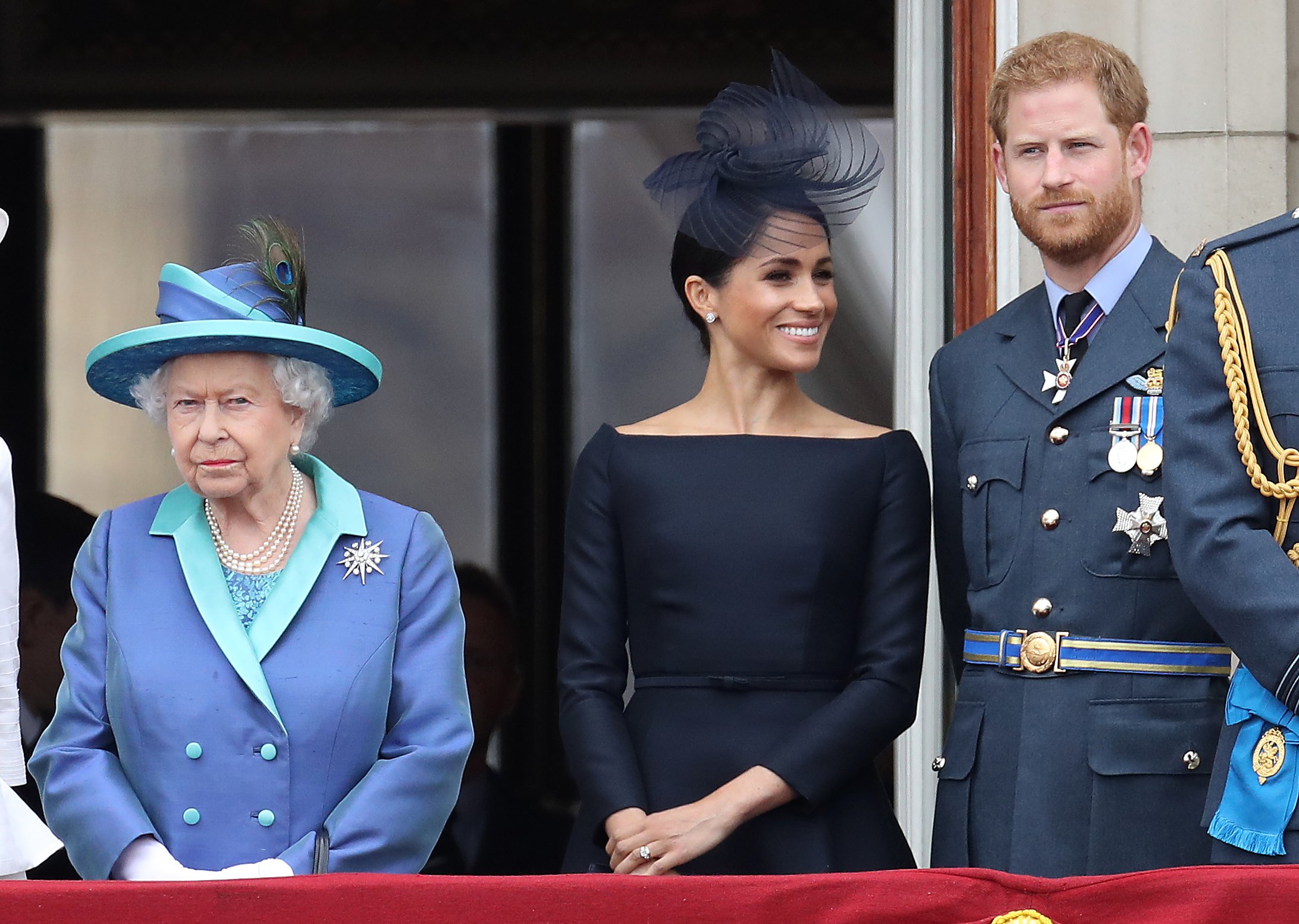 Queen Elizabeth II, Prince Harry, Duke of Sussex and Meghan, Duchess of Sussex on the balcony of Buckingham Palace as the Royal family attend events to mark the Centenary of the RAF on July 10, 2018 in London, England. | Source: Getty Images