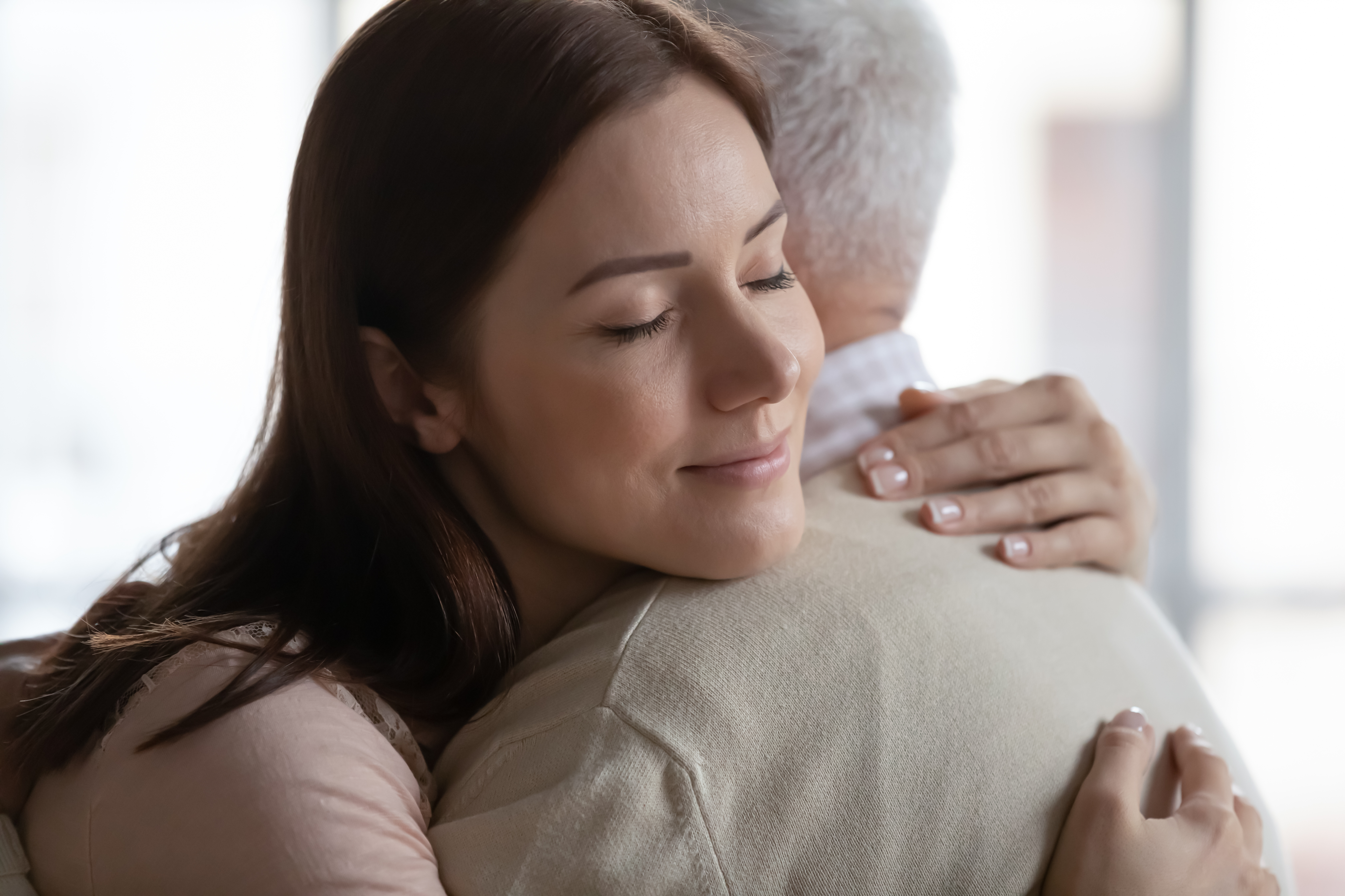 Eine junge Frau umarmt emotional ihren Vater | Quelle: Shutterstock