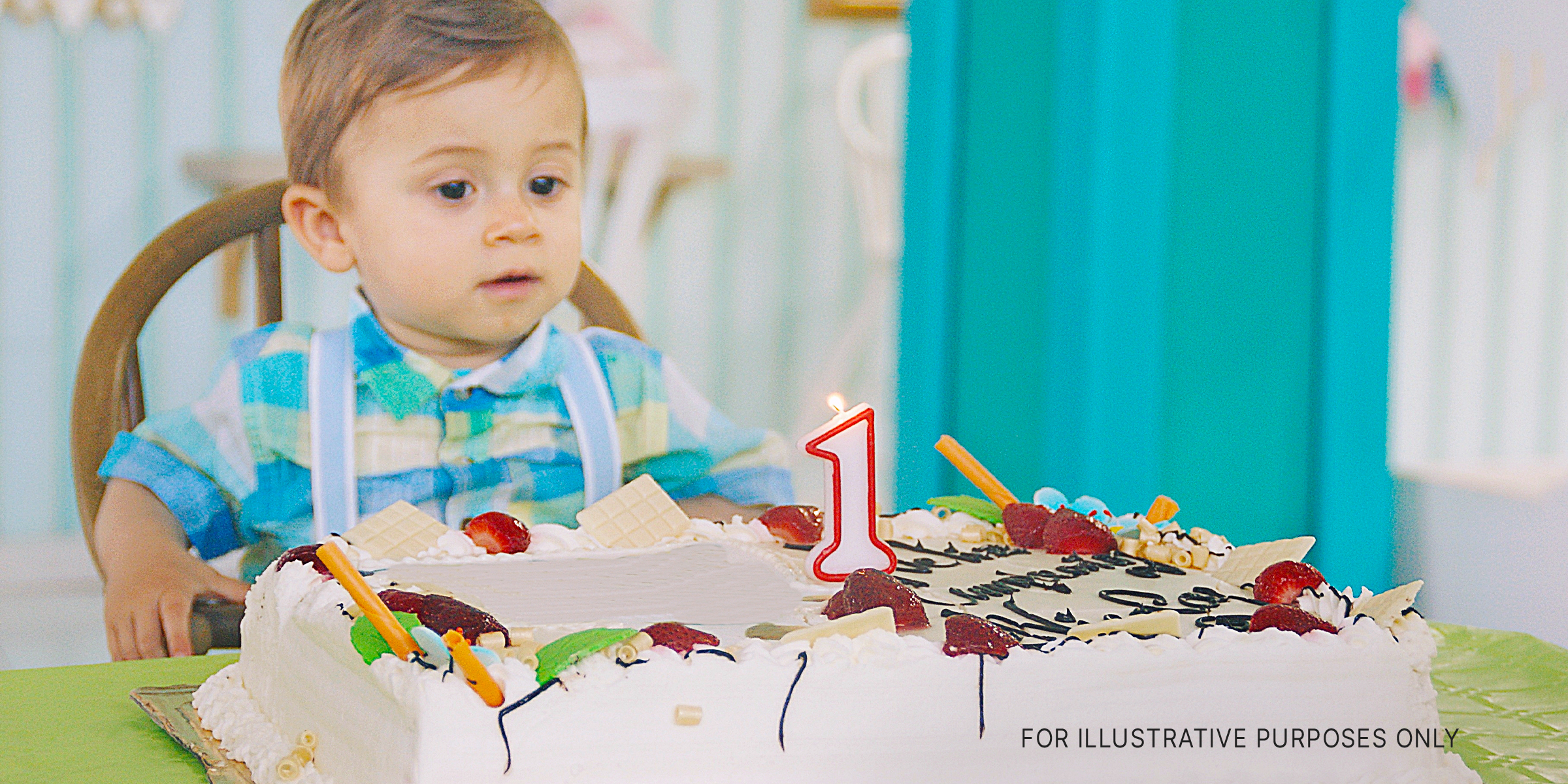 A toddler sitting at a table ready to blow out a candle on his birthday cake | Source: Getty Images