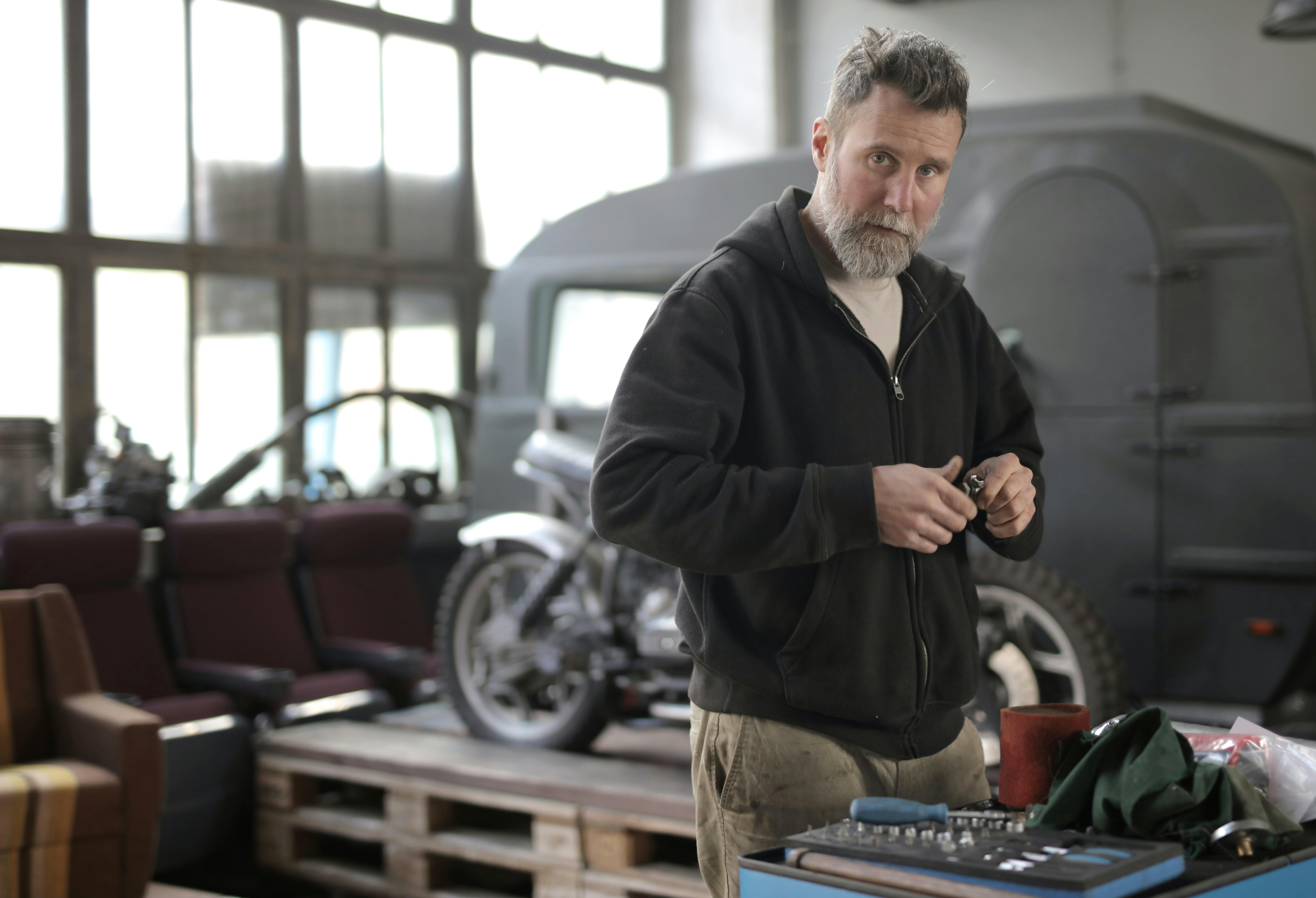 A man in a black jacket inside a machine shop | Source: Pexels