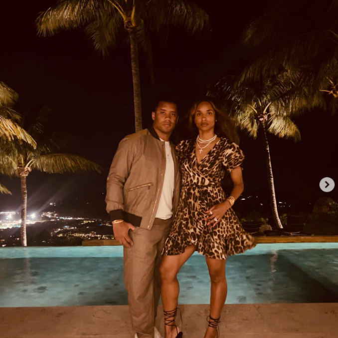 Ciara and Russell Wilson pose in front of a pool on March 13, 2022 | Source: Instagram/ciara