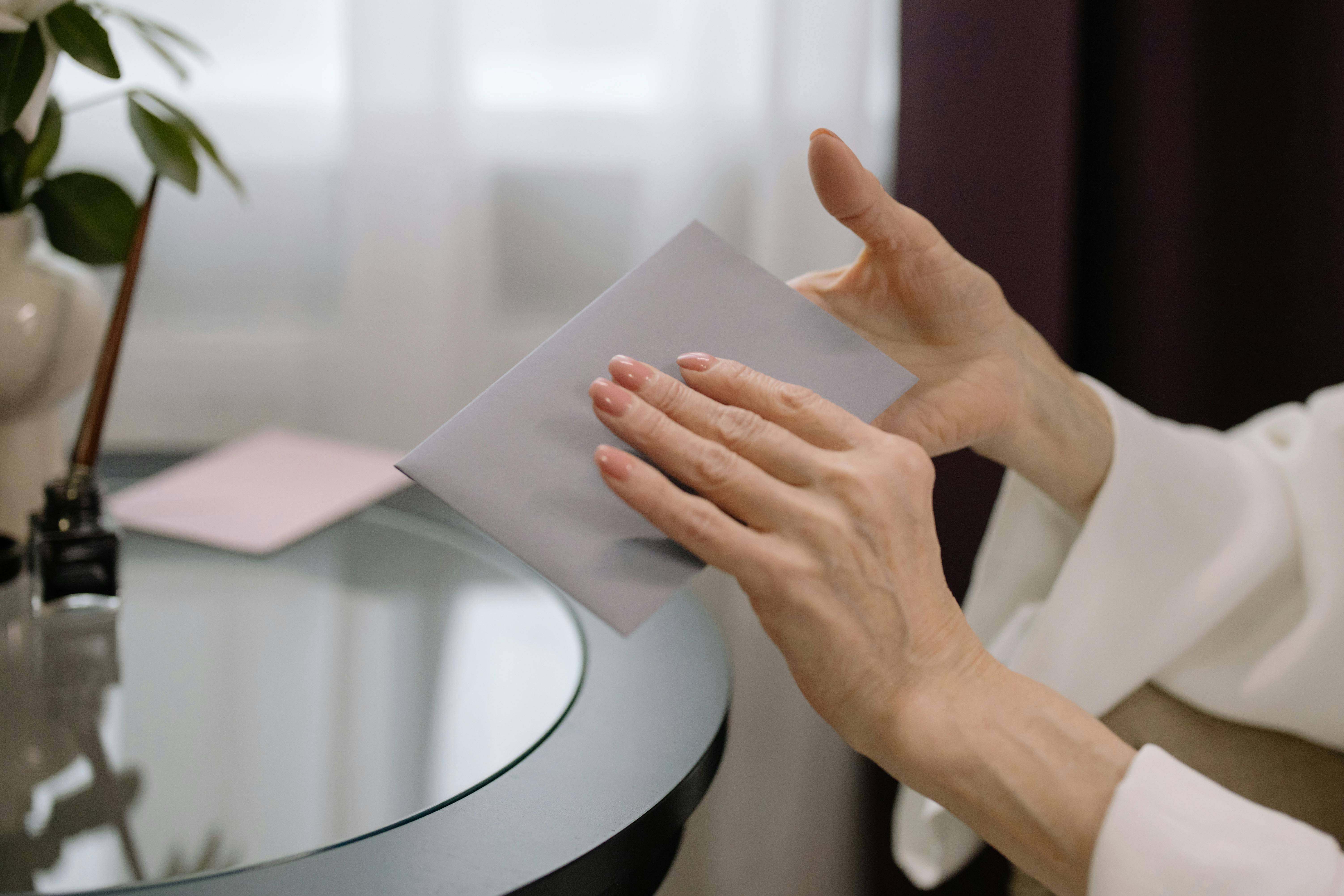 A person holding a white envelope | Source: Pexels