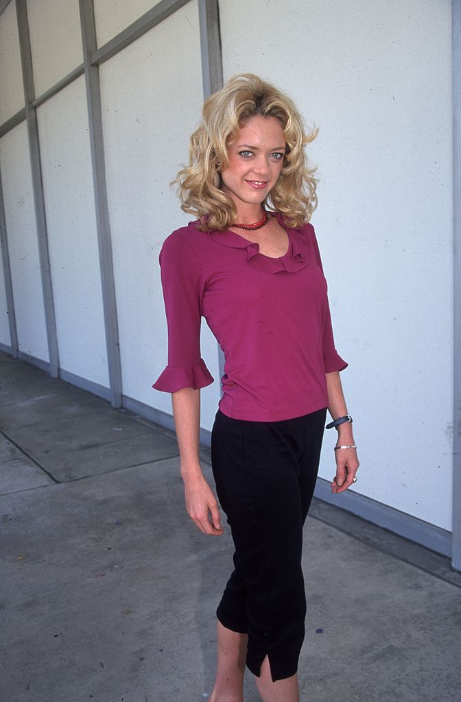 American actor Lisa Robin Kelly wearing a fuchsia blouse with a ruffled neckline and black Capri pants, standing on a film lot, Beverly Hills, California on  April 12, 2000 | Photo: Getty images