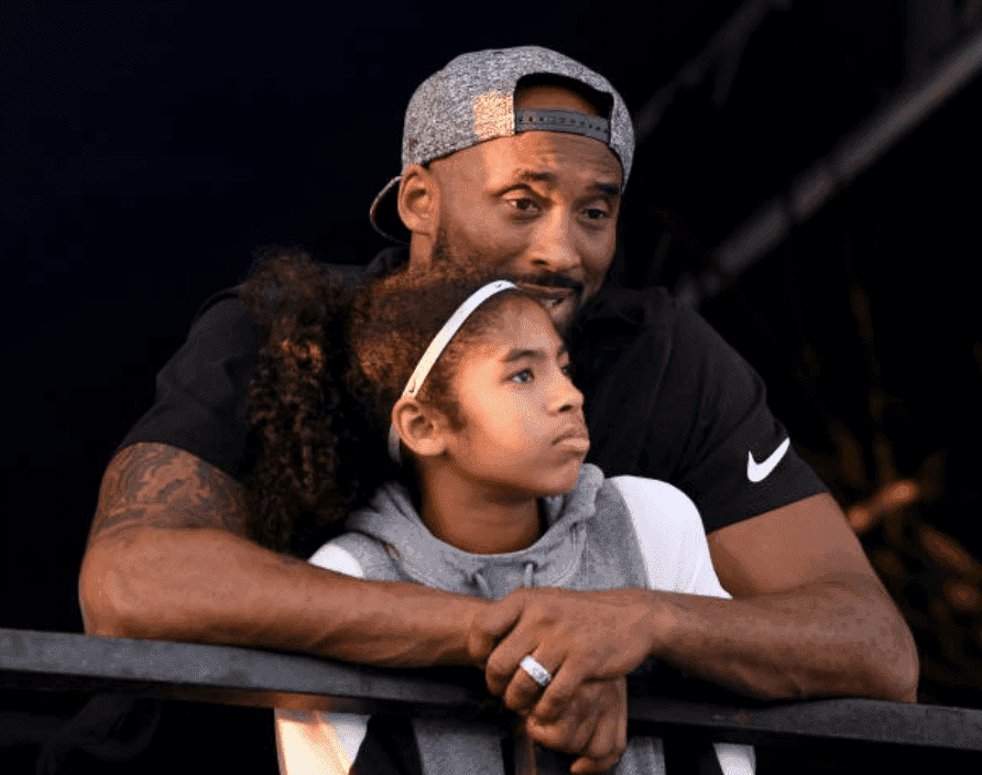 Kobe Bryant and hugs his daughter Gianna Bryant as they watch the Phillips 66 National Swimming Championships, at the Woollett Aquatics Center, on July 26, 2018, in Irvine, California | Source:  Harry How/Getty Images