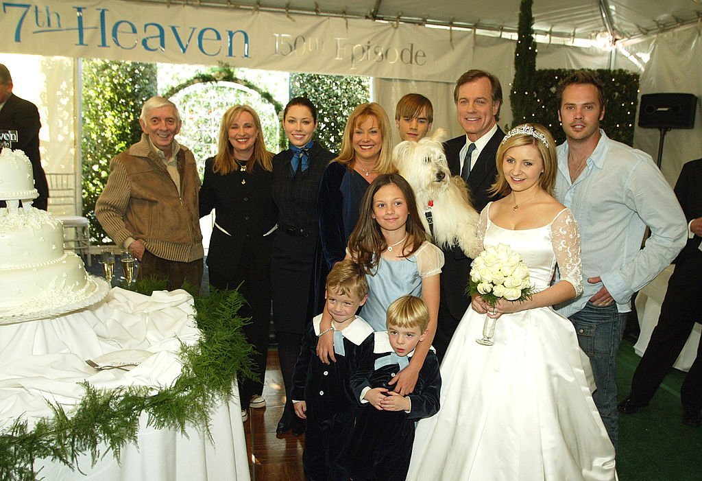 Exec. prod. Aaron Spelling and exec. prod./creator Brenda Hampton with the family, (L to R, rear) actors Jessica Biel, Catherine Hicks, David Gallagher, Stephen Collins, Barry Watson, (front) twins Nikolas and Lorenzo Brino, Mackenzie Rosman and Beverley Mitchell pose at a reception to celebrate 150 episodes | Getty Images