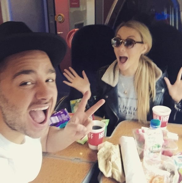 Taken on 26 April 2015, Adam and Caroline Thomas appear in high spirits as they pose for a playful selfie on a train, surrounded by snacks and drinks — a lively and spontaneous moment that captures the couple's fun-loving dynamic during their early years together. | Source: Instagram/carolinethomas23