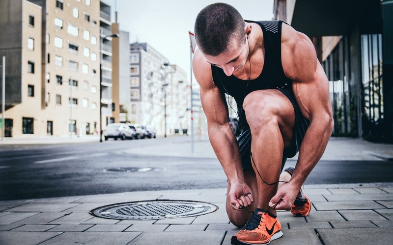 homme qui fait ses lacets. | Photo : Unsplash