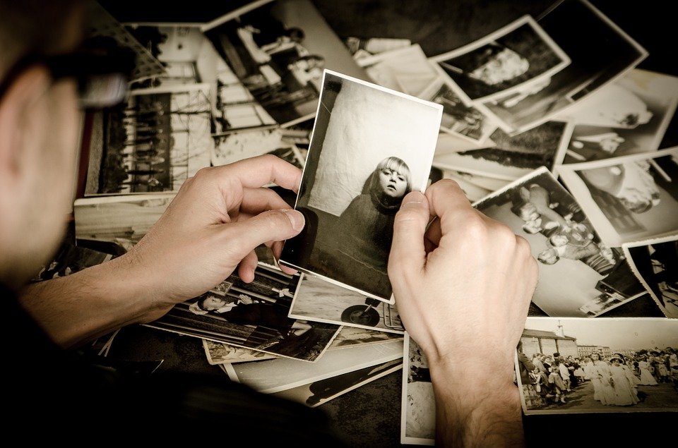 Hombre viendo fotos antiguas. | Foto: Pixabay