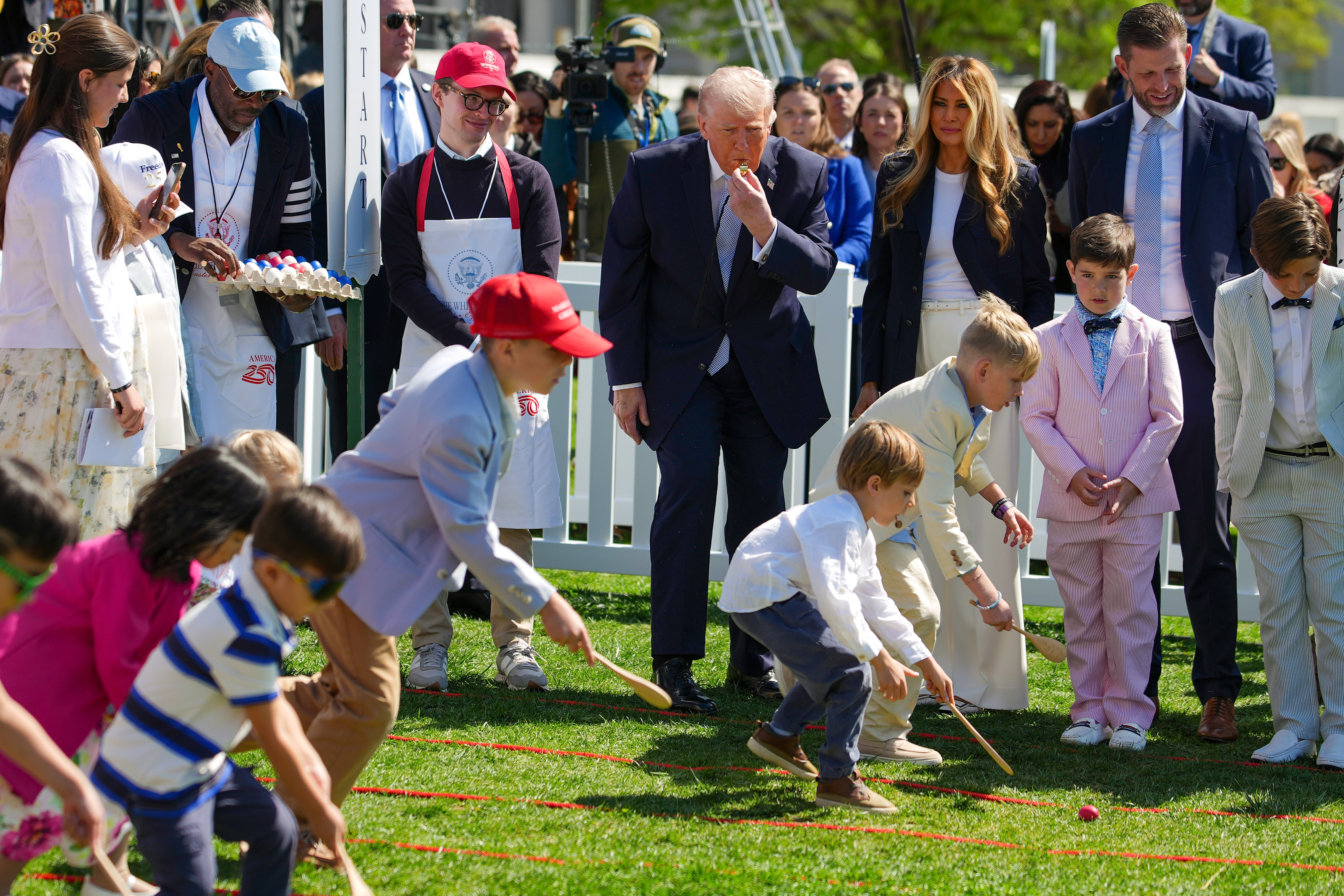 Donald Trump blows a whistle to start an Egg Roll race as Melania Trump, Eric Trump, and children look on during the event on the South Lawn.
