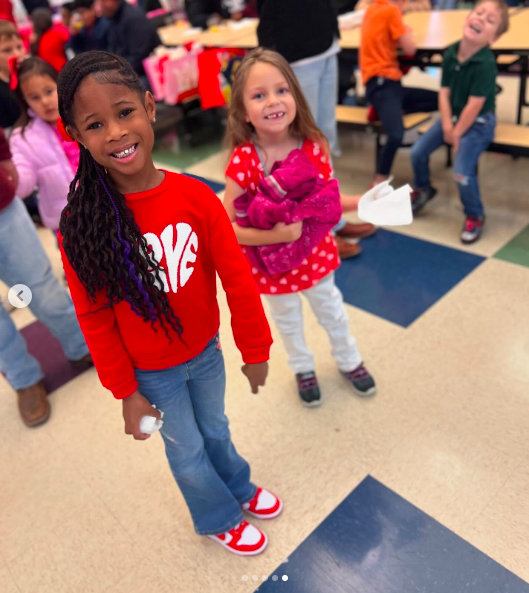 R'Mani and her friend smiling for a picture amid other little kids. | Source: Instagram/hoodfamelilronnie