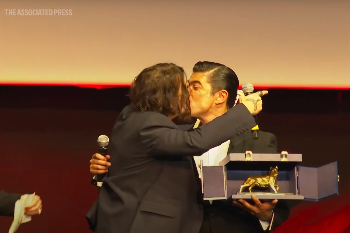 Johnny Depp and Riccardo Scamarcio sharing a peck. | Source: YouTube/Associated Press