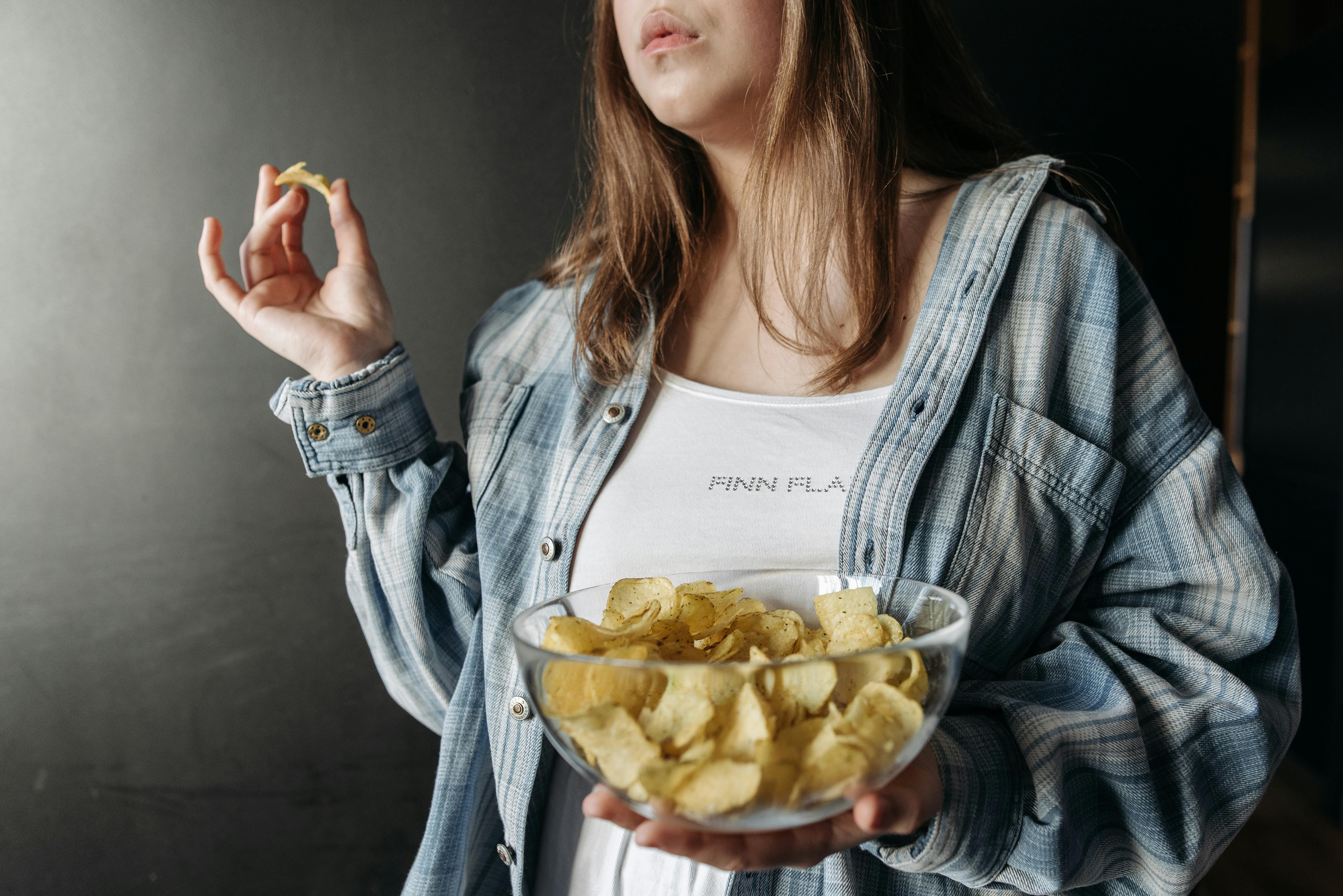 A woman snacking on chips | Source: Pexels