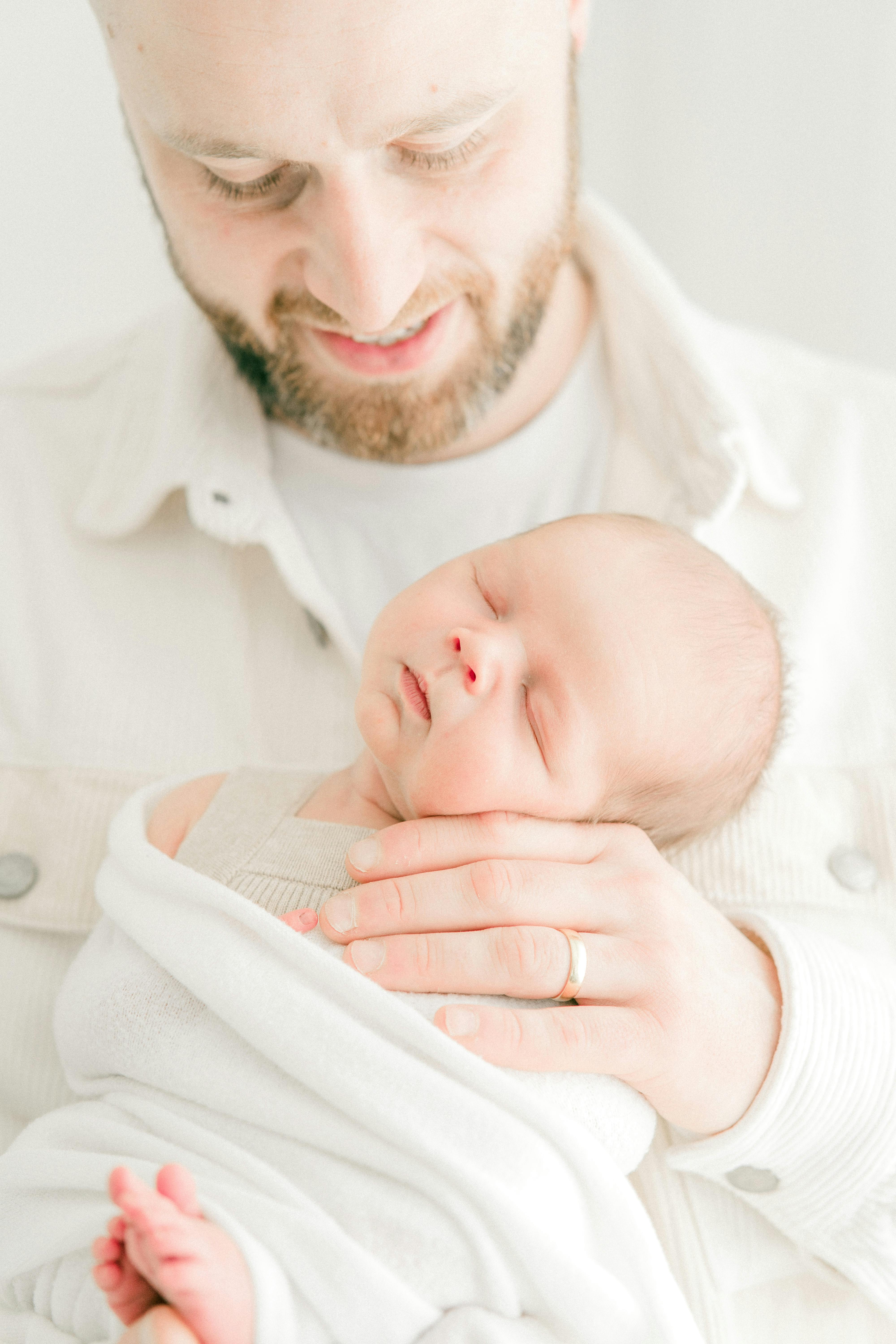 A newborn baby held by a happy father | Source: Pexels