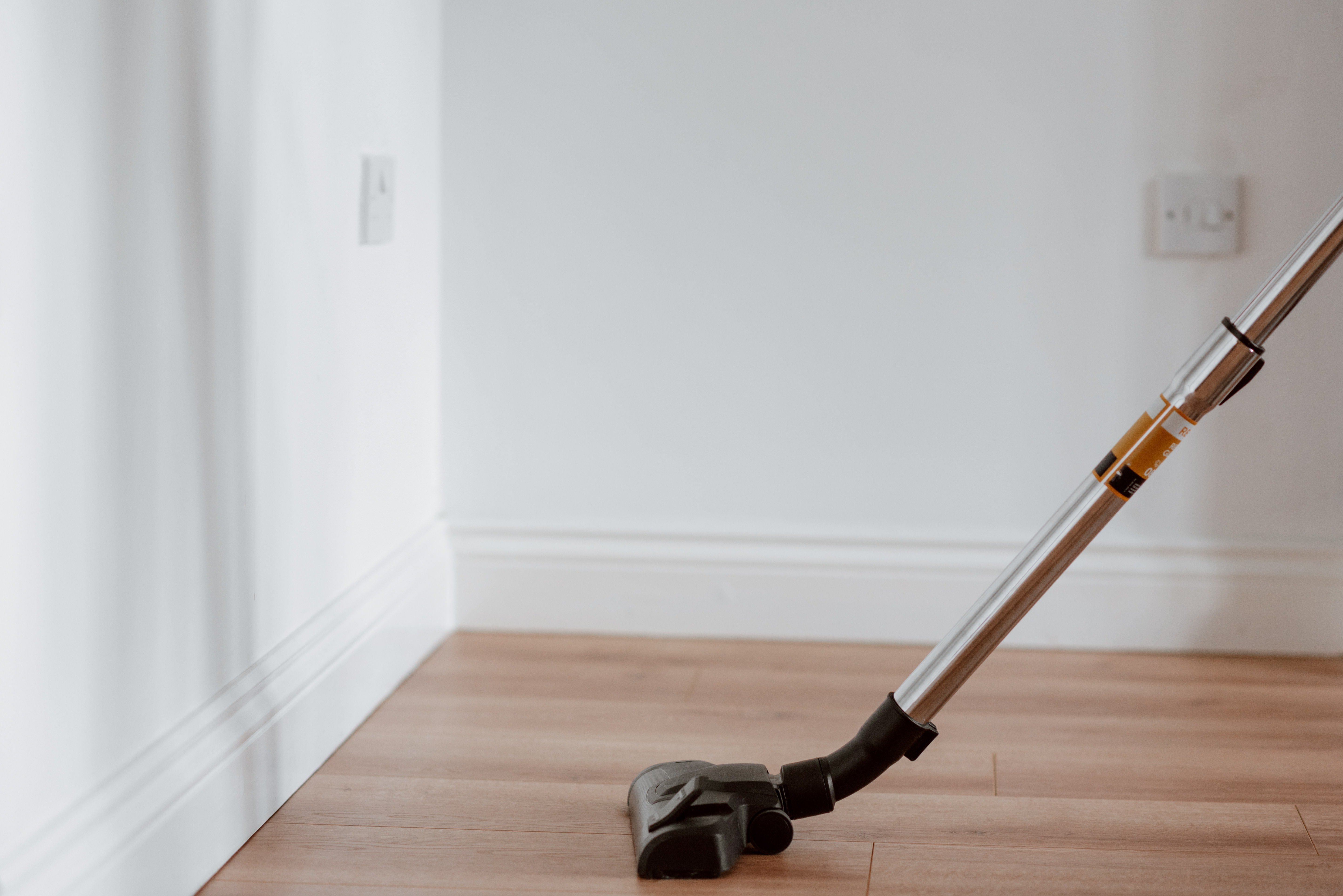 A vacuum cleaner on a wooden floor. | Photo: Pexels