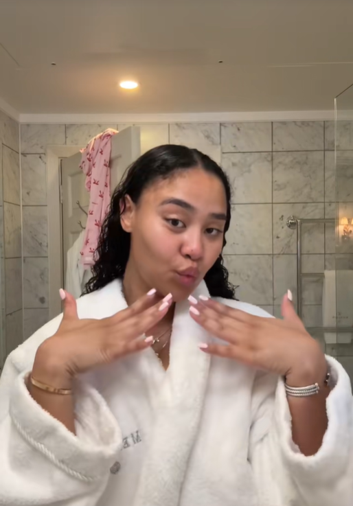 Brianna McKnight faces the mirror with both hands raised near her jawline, from a post dated December 4, 2025. | Source: TikTok/brimcknighttt