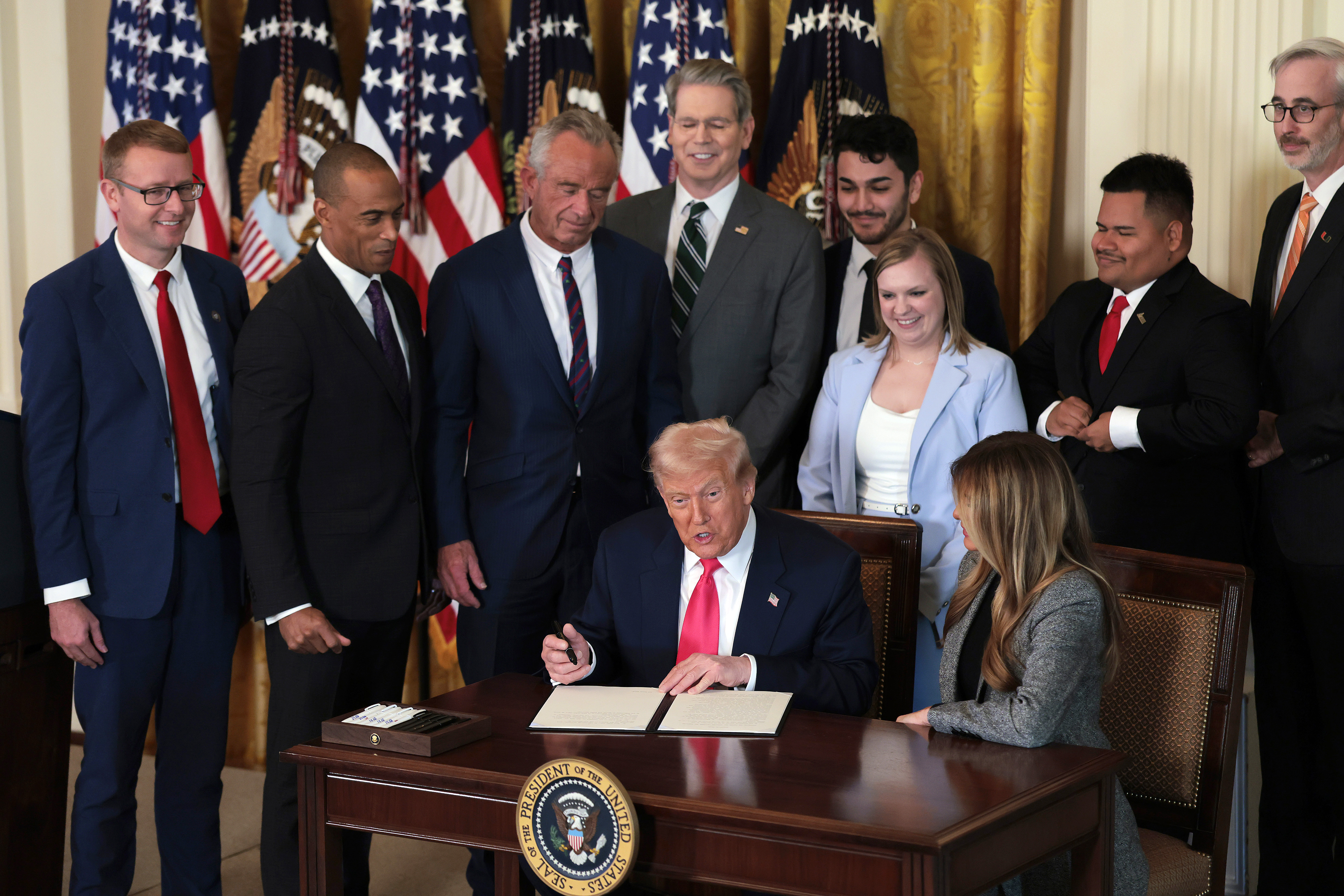 Donald Trump joined by Melania Trump and members of his administration and foster care advocates, signs the "Fostering the Future" executive order on November 13, 2025 | Source: Getty Images