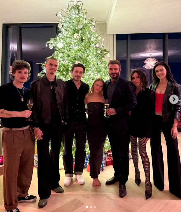 Victoria, David, Harper, Brooklyn, Romeo, and Cruz Beckham, and Nicola Peltz pose in front of a Christmas tree in a post dated December 26, 2024 | Source: Instagram/victoriabeckham