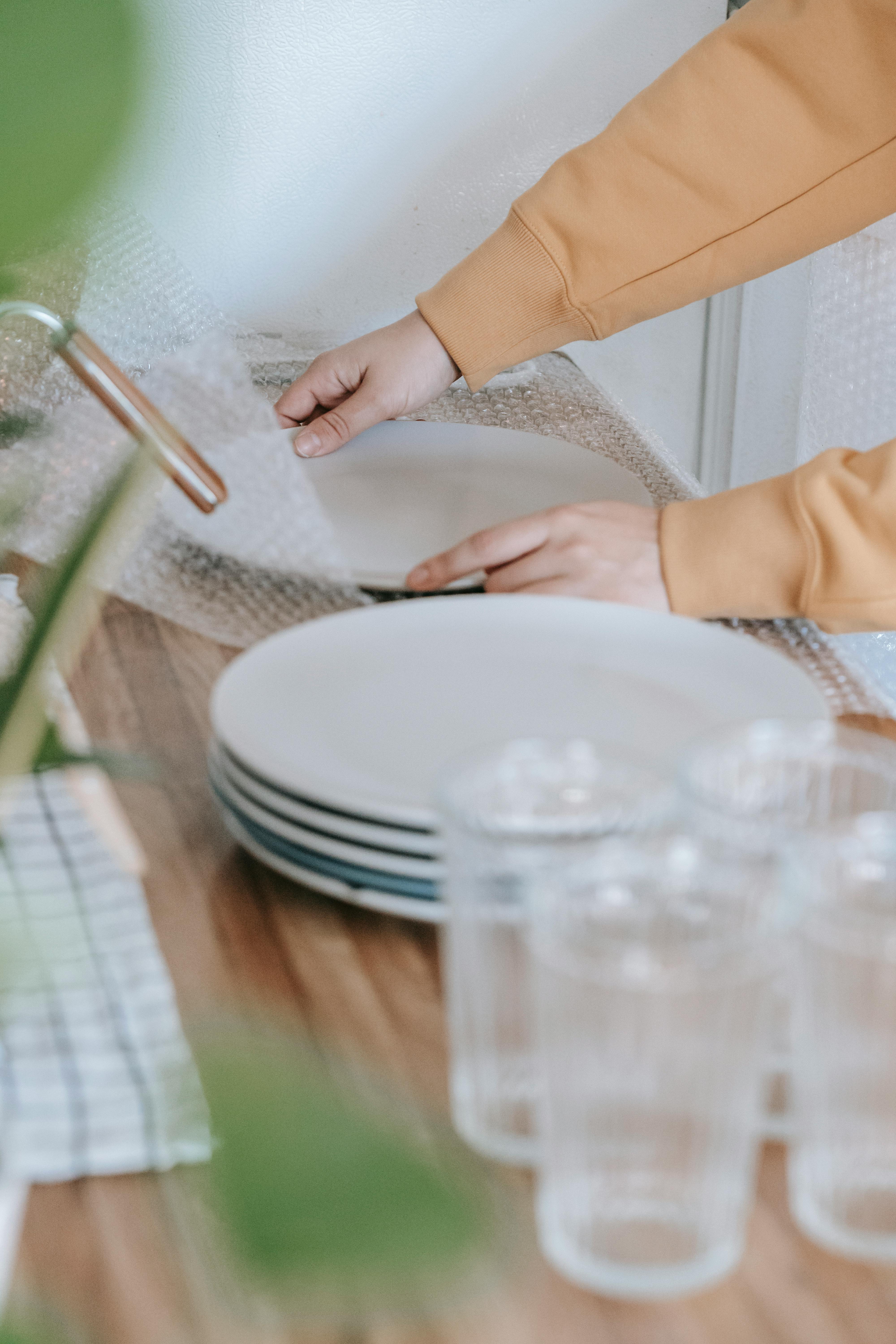 A woman putting bubble wrap on plates | Source: Pexels