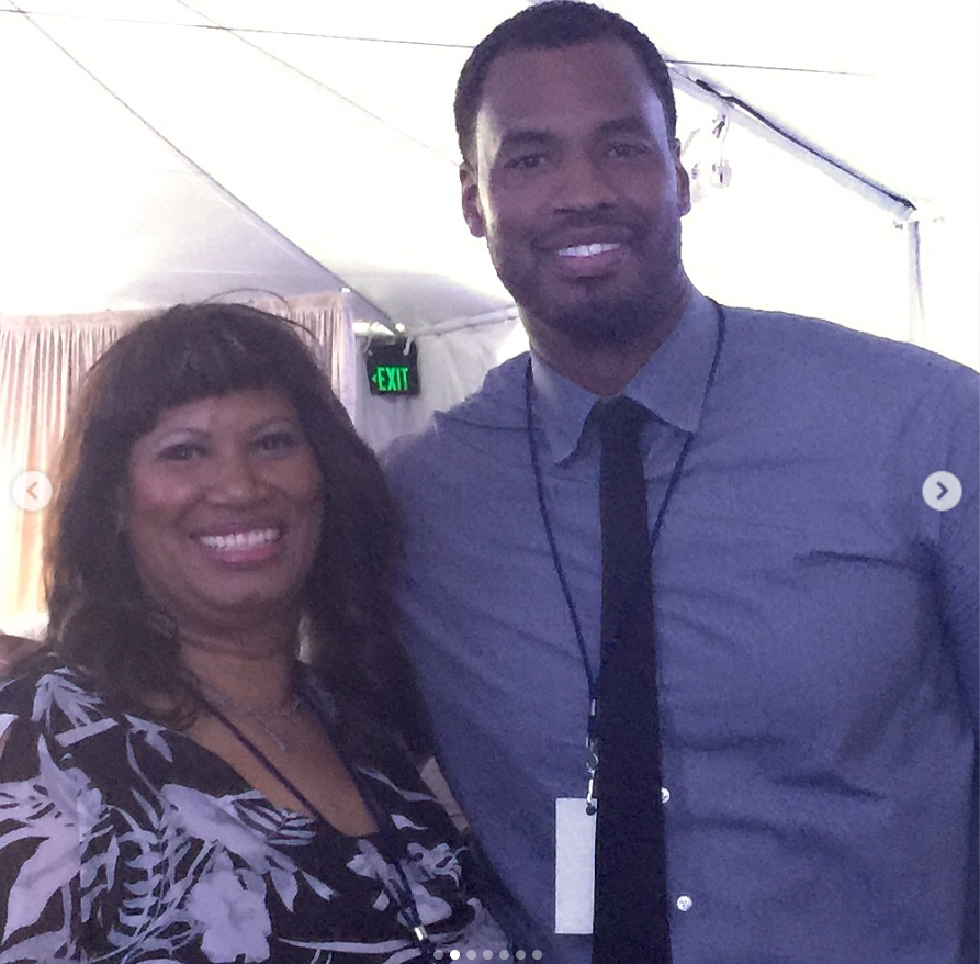 Jason Collins smiles beside his mother, Portia Collins, while posing together at an event in a warmly lit venue. | Source: Instagram/jasoncollins_98