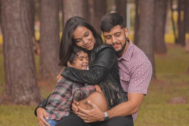 Man hugging pregnant woman and child | Source: Unsplash