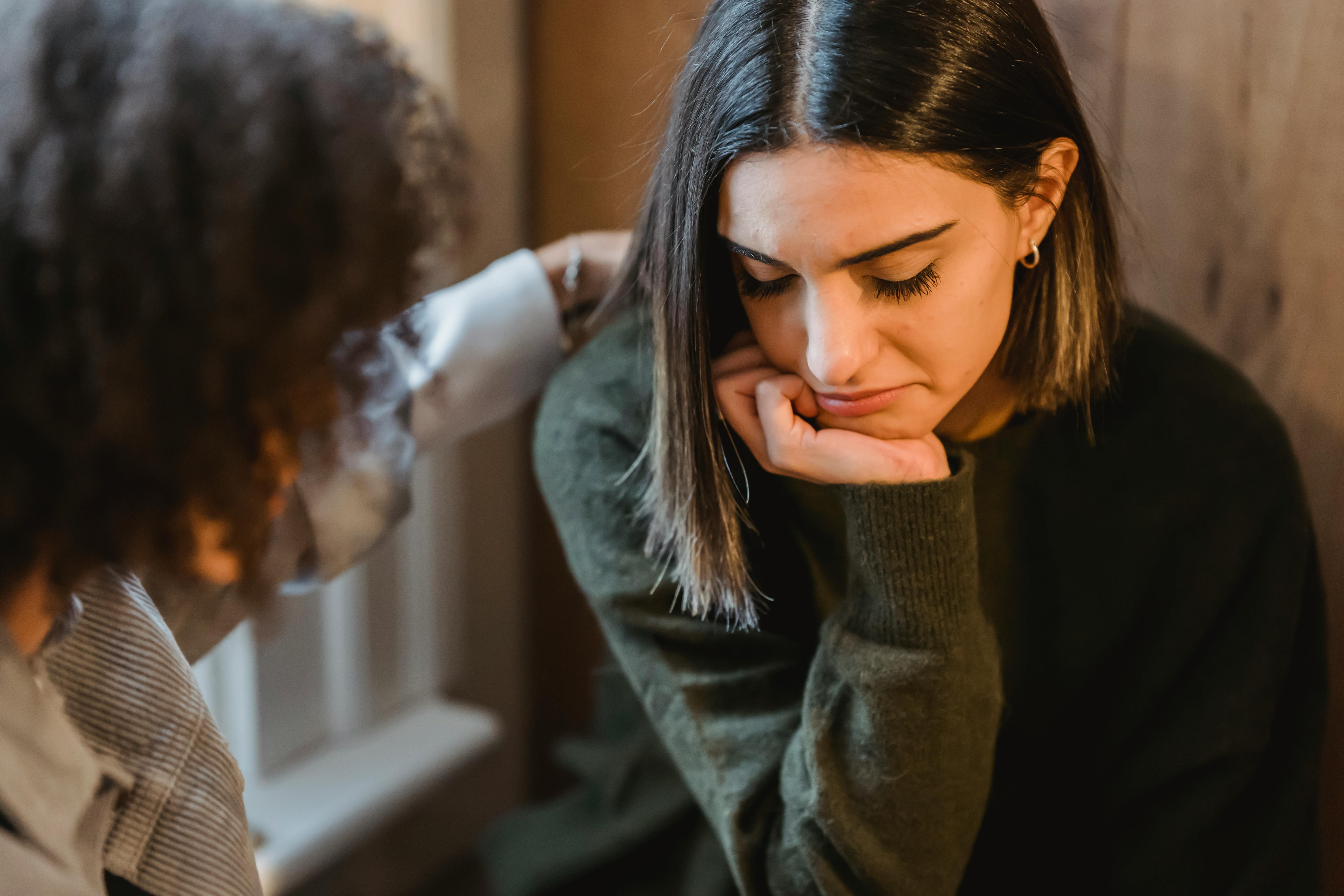 A sad woman being comforted by another woman | Source: Pexels