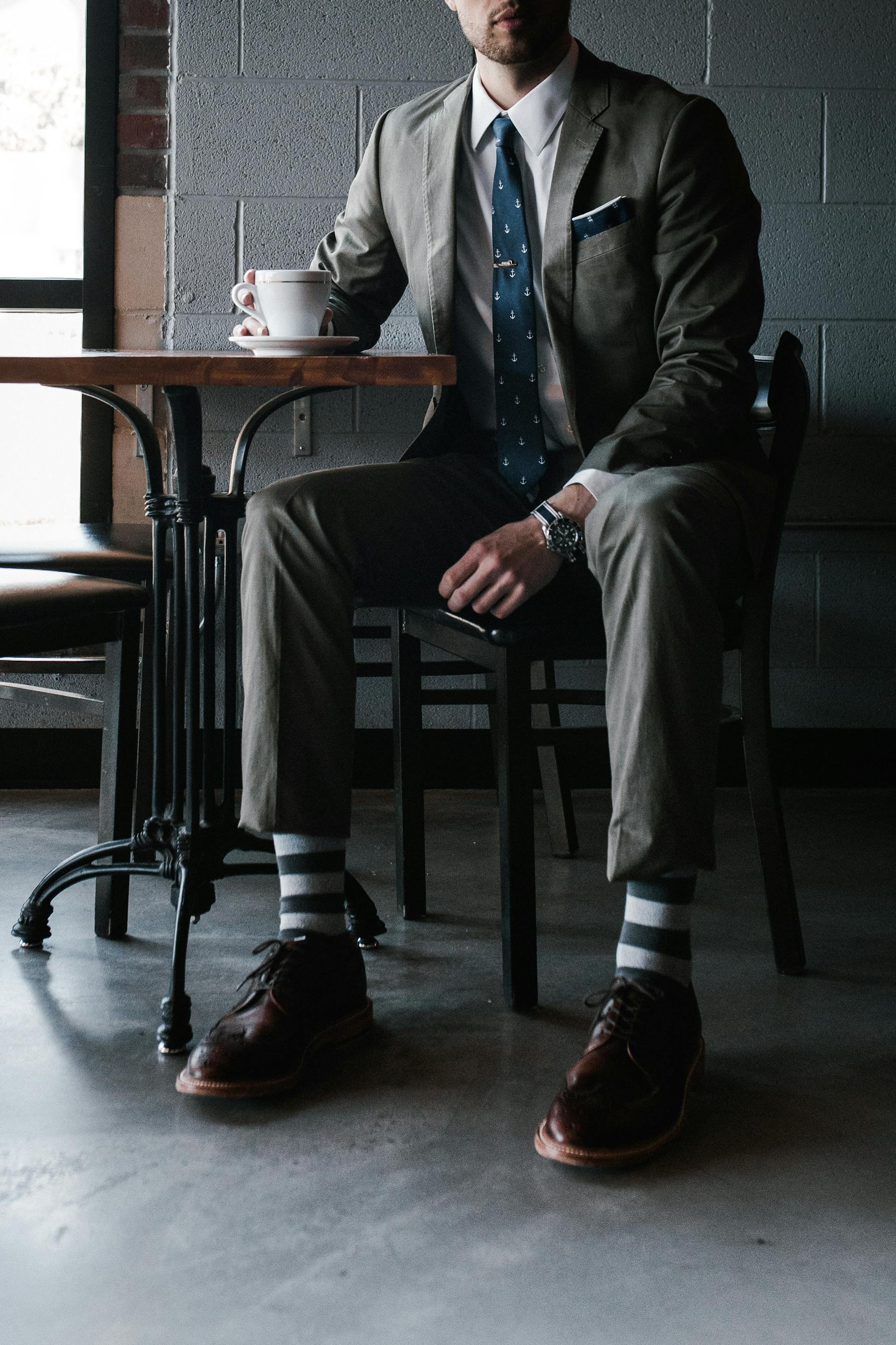 A man in a suit sitting at a table | Source: Pexels