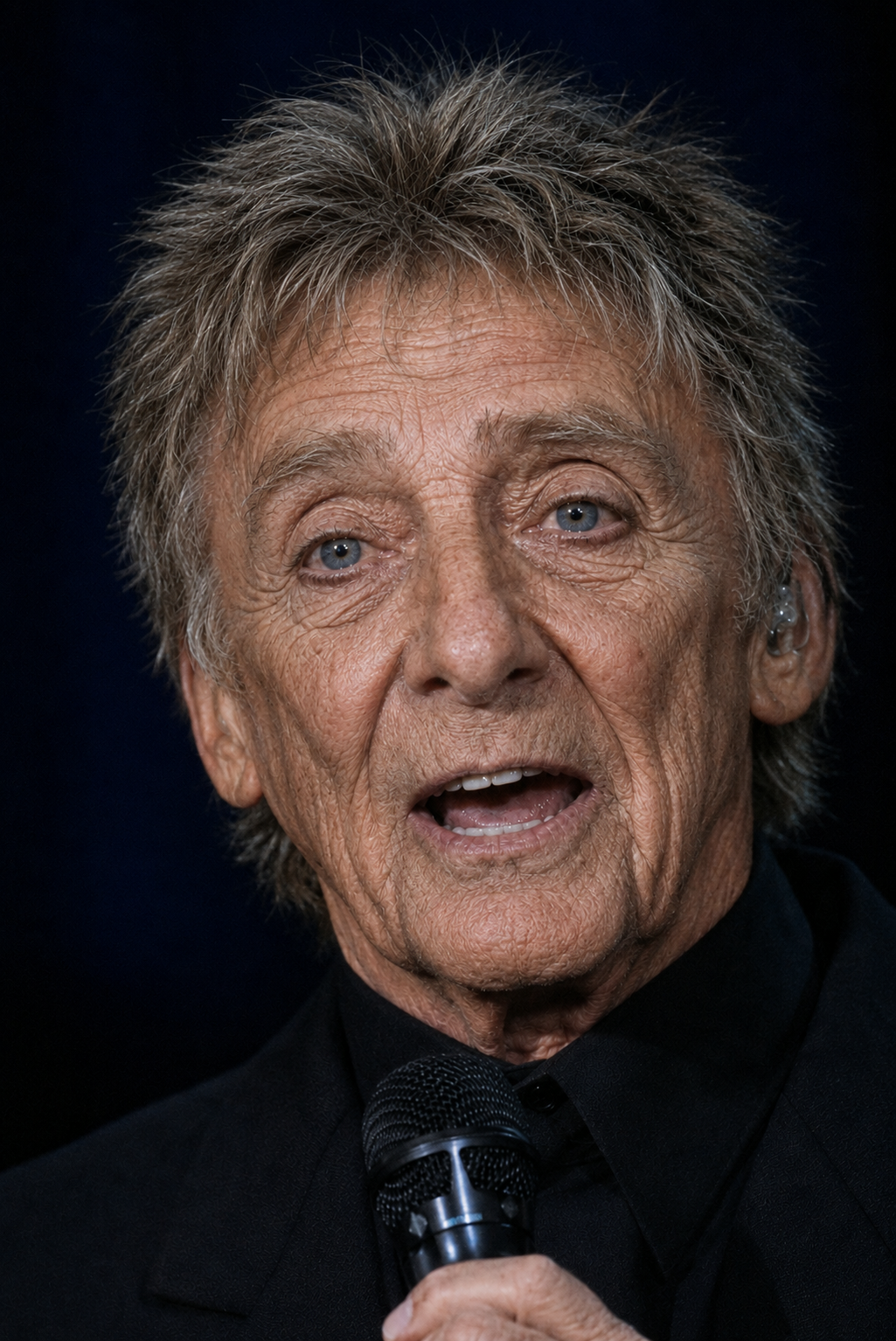 This tight close-up removes most of the stage setting and keeps attention on Manilow's face. It is one of the clearest images in the set for comparing expression and overall facial appearance. | Source: ChatGPT