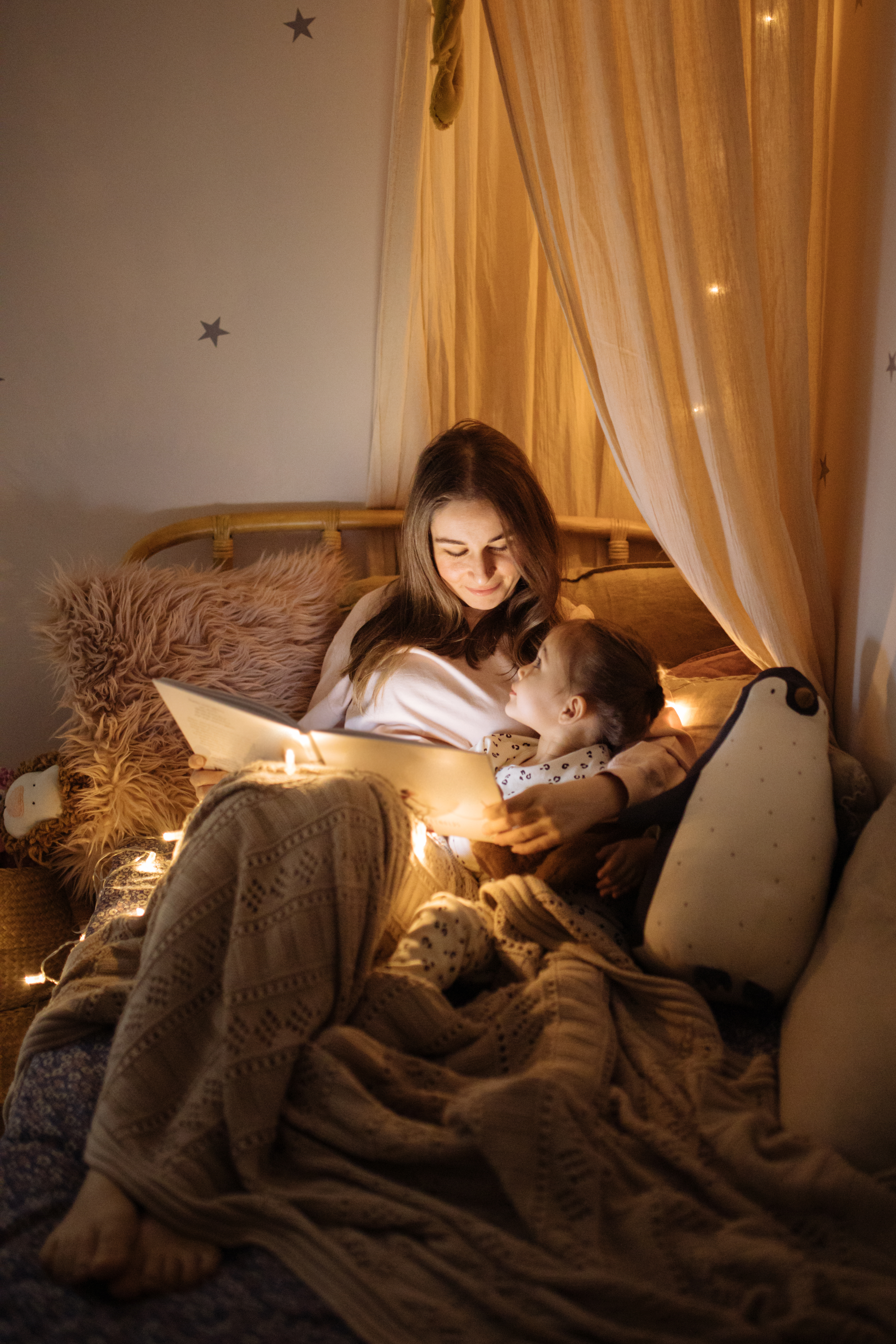Mother and child reading book in bed before going to sleep | Source: Getty Images
