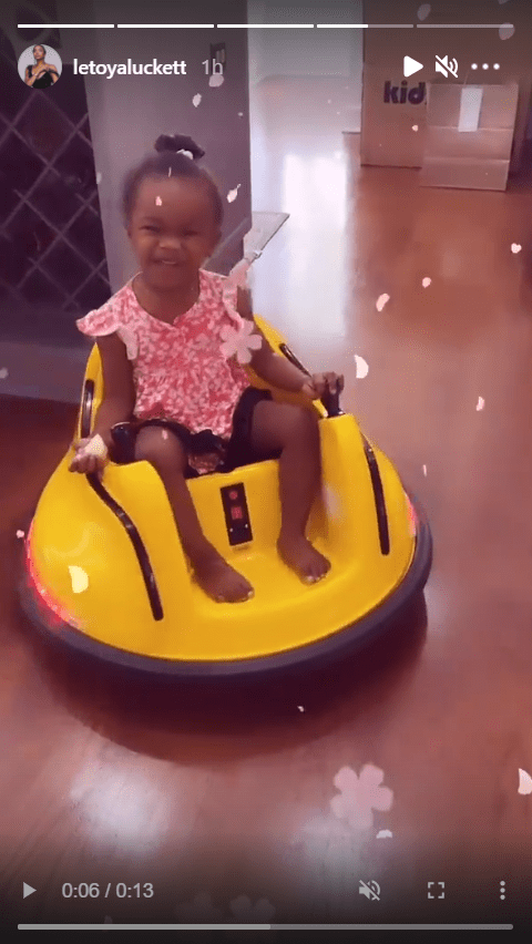 LeToya Luckett's daughter, Gianna, dressed in a cute pink dress while riding a yellow bumper car | Photo: Instagram/letoyaluckett