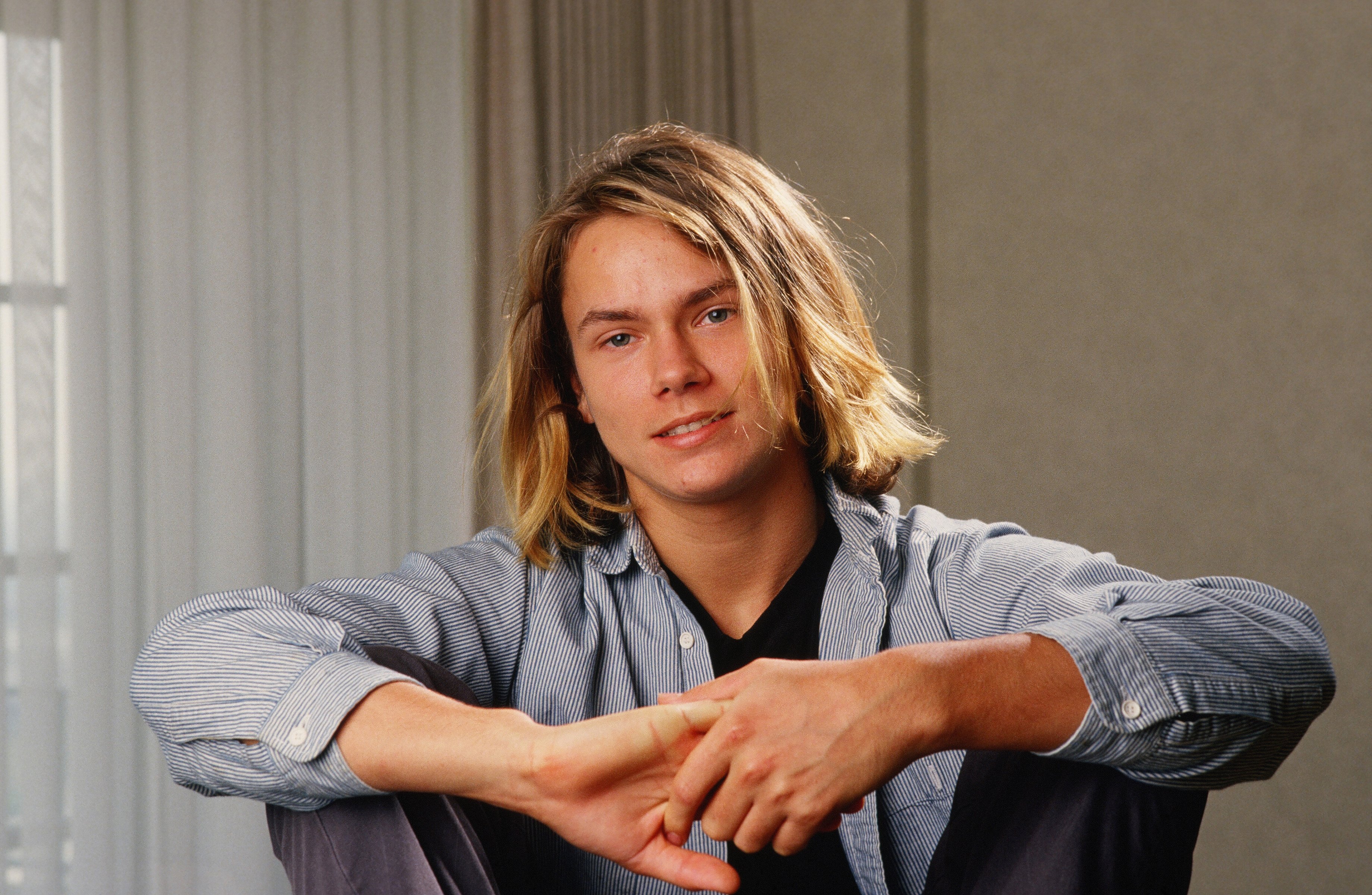 River Phoenix (Joaquin Phoenix's late brother) posing during a portrait session in Los Angeles, California in 1988. | Source: Getty Images