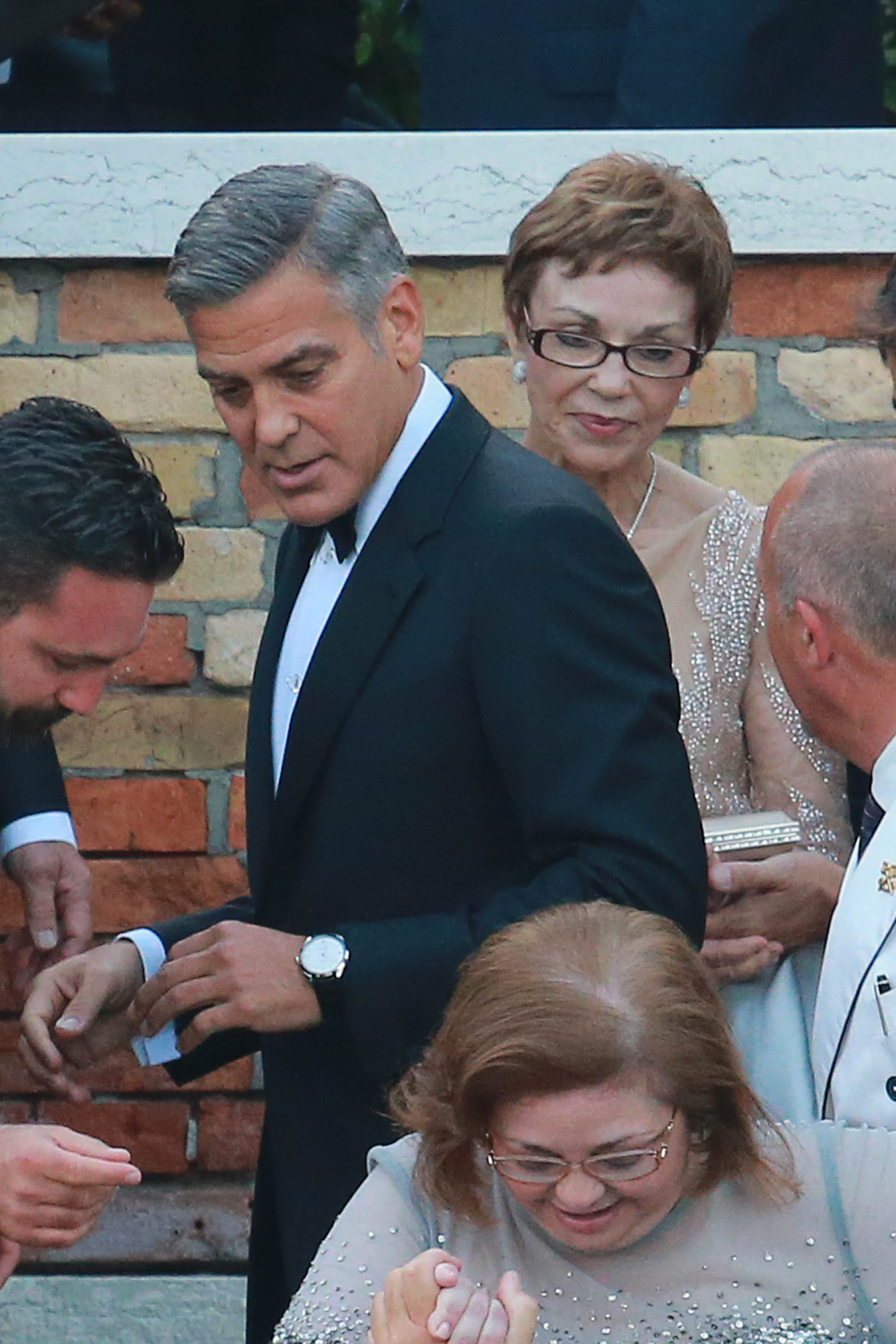 George Clooney walks closely behind his sister Ada Zeidler as their family makes their way to a wedding event in Venice | Source: Getty Images