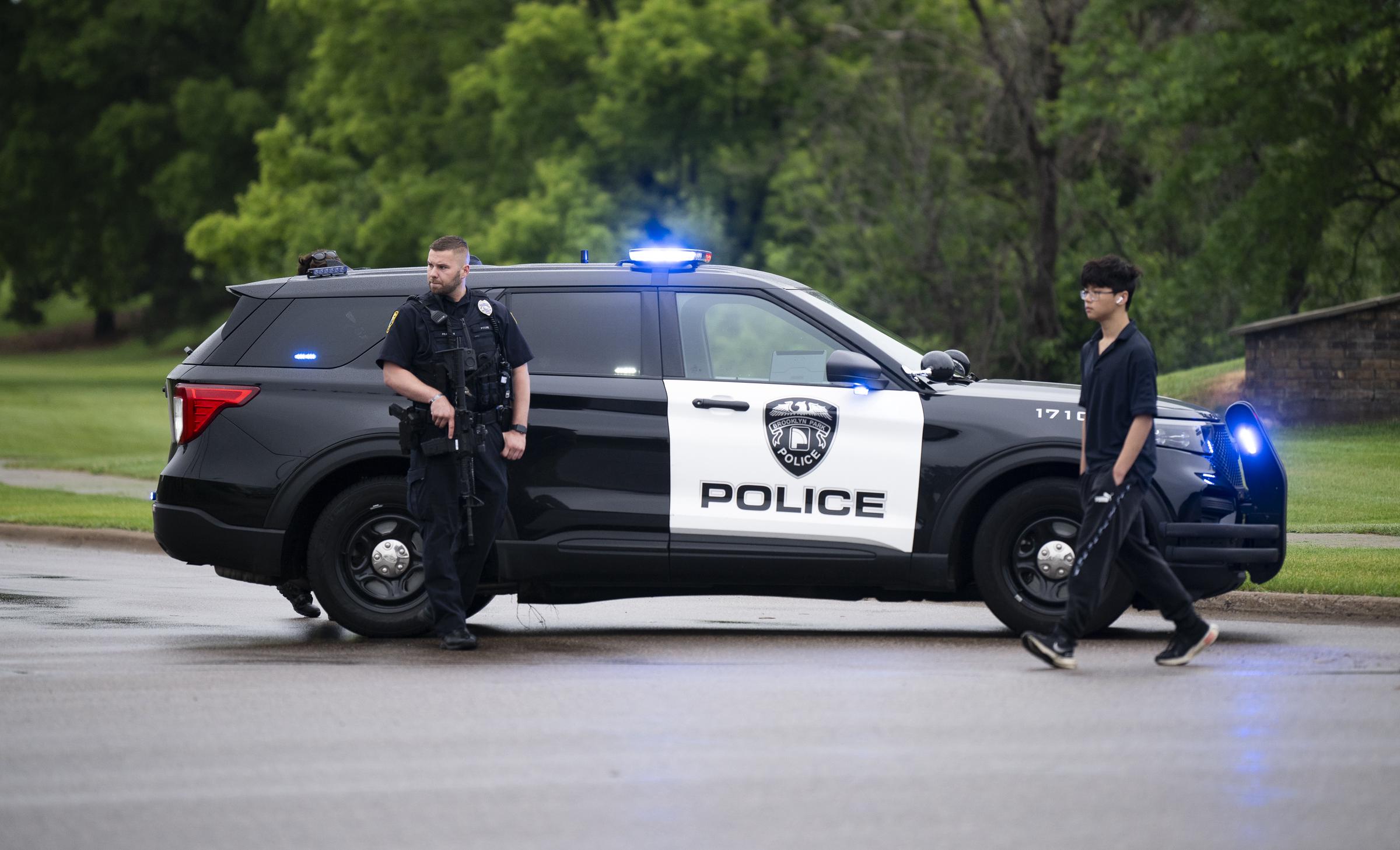 A Brooklyn Park police officer looks on as they guard the entrance to a neighborhood on June 14, 2025 in Brooklyn Park, Minnesota. | Source: Getty Images