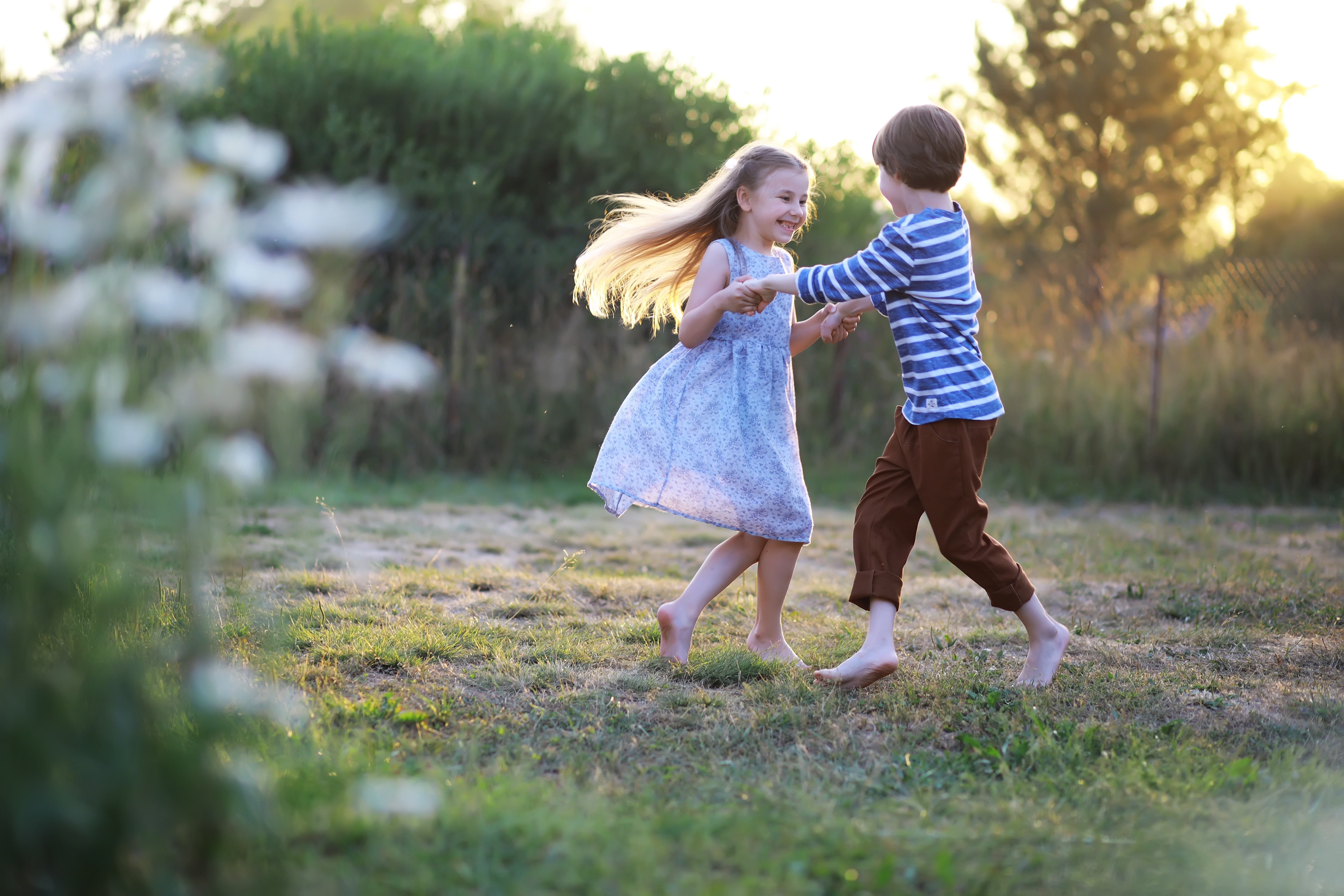 A young boy is pictured playing with a young girl in the park | Source: Shutterstock